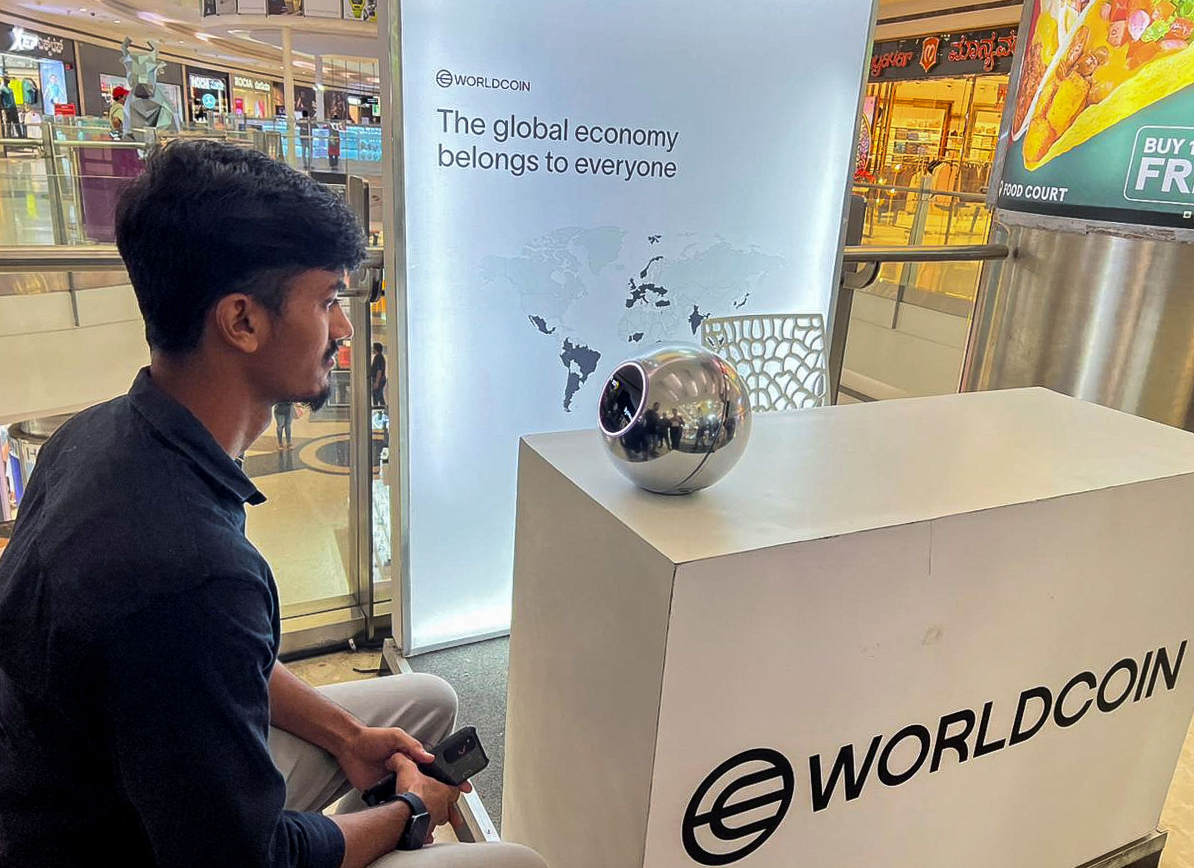 Un joven de 22 años en Bangalore entrega la información biométrica de su iris a un Orb de Worldcoin.