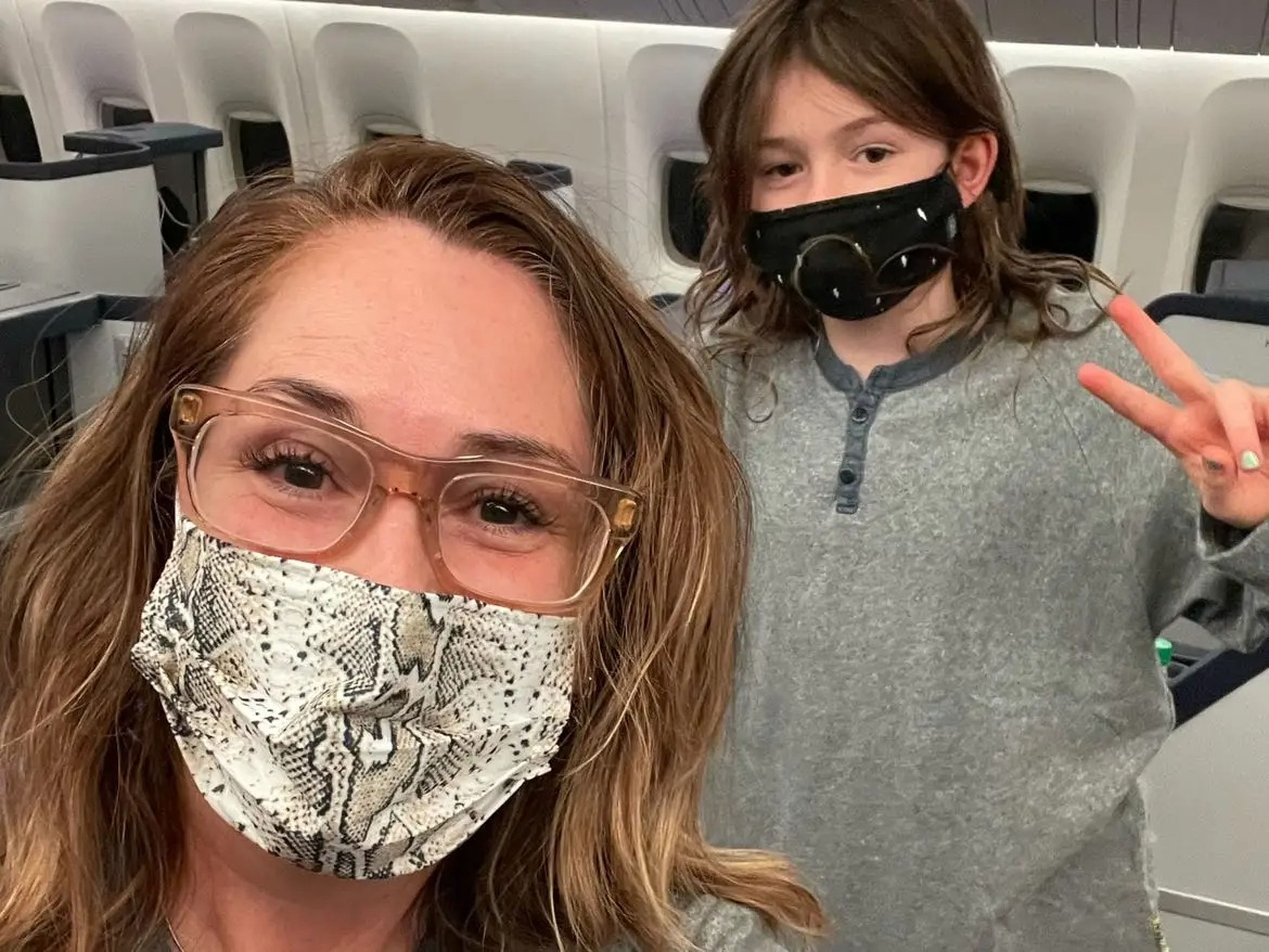 Mother and daughter on flight wearing facemasks