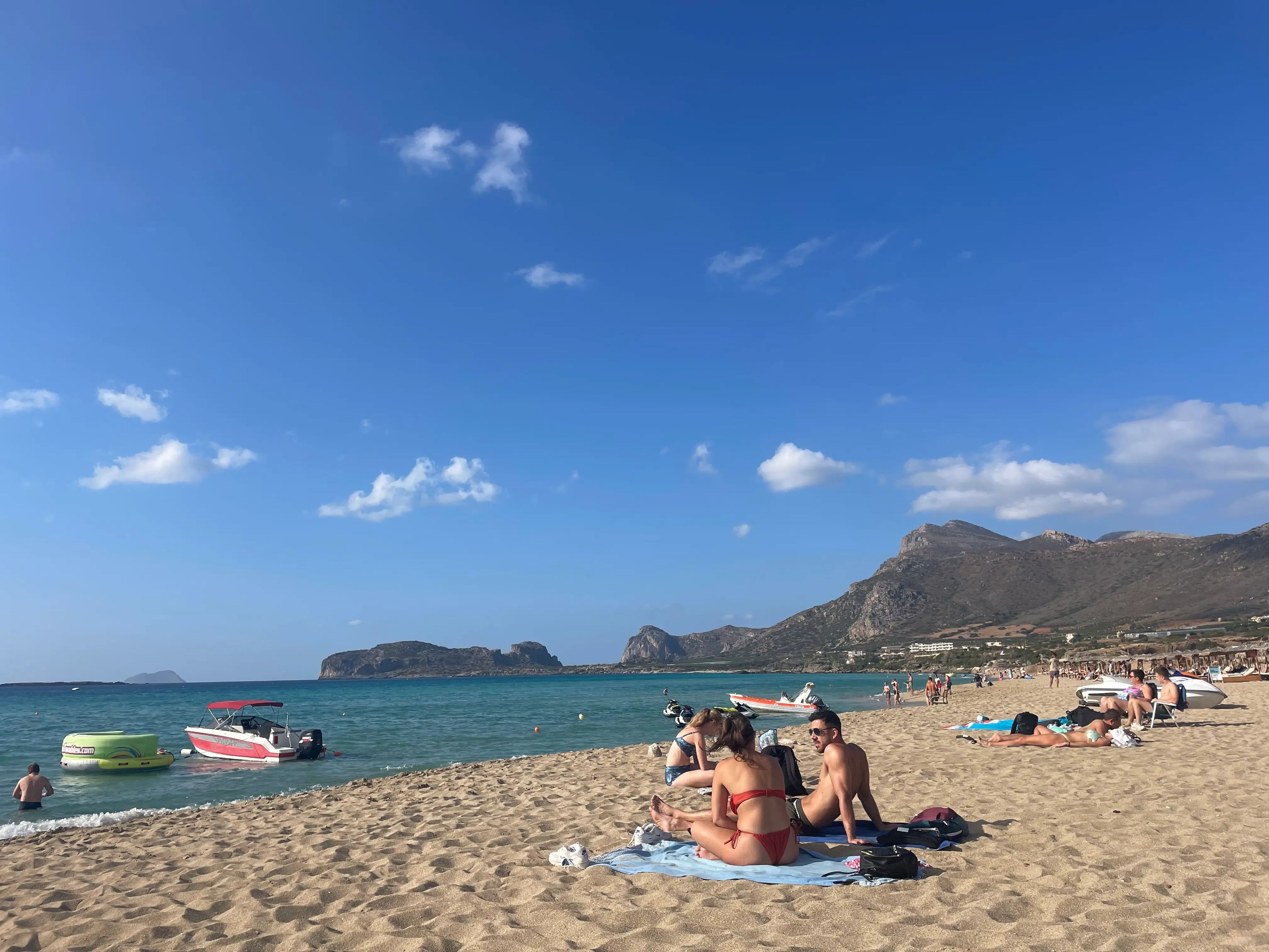 people lounging in the sand at falasarna beach in create greece