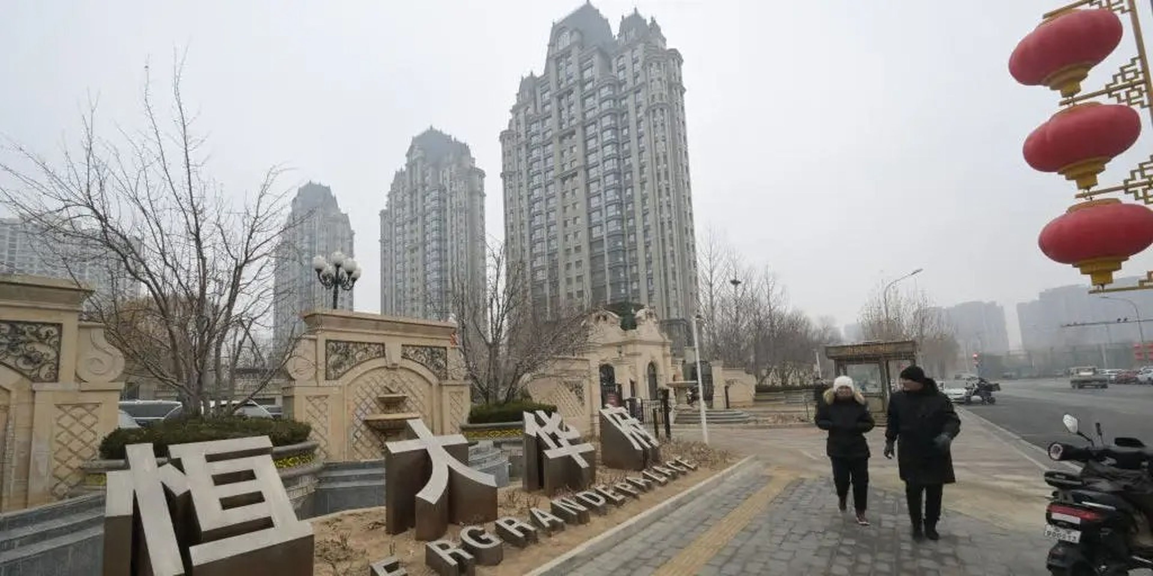 People walk past an Evergrande Group residential complex called Evergrande Palace in Beijing on January 30, 2024.