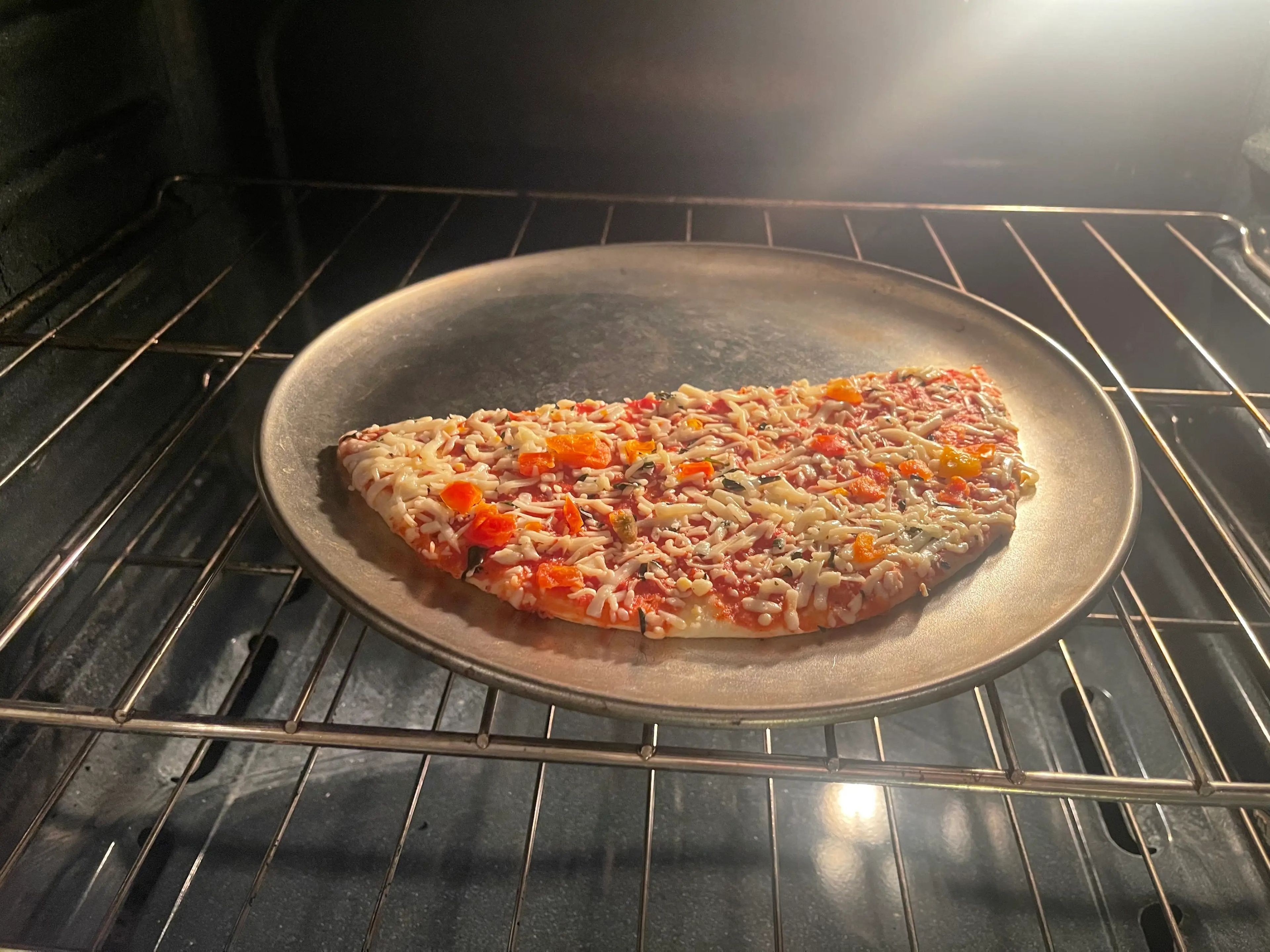 Coloqué la pizza en una bandeja y la metí en el horno.