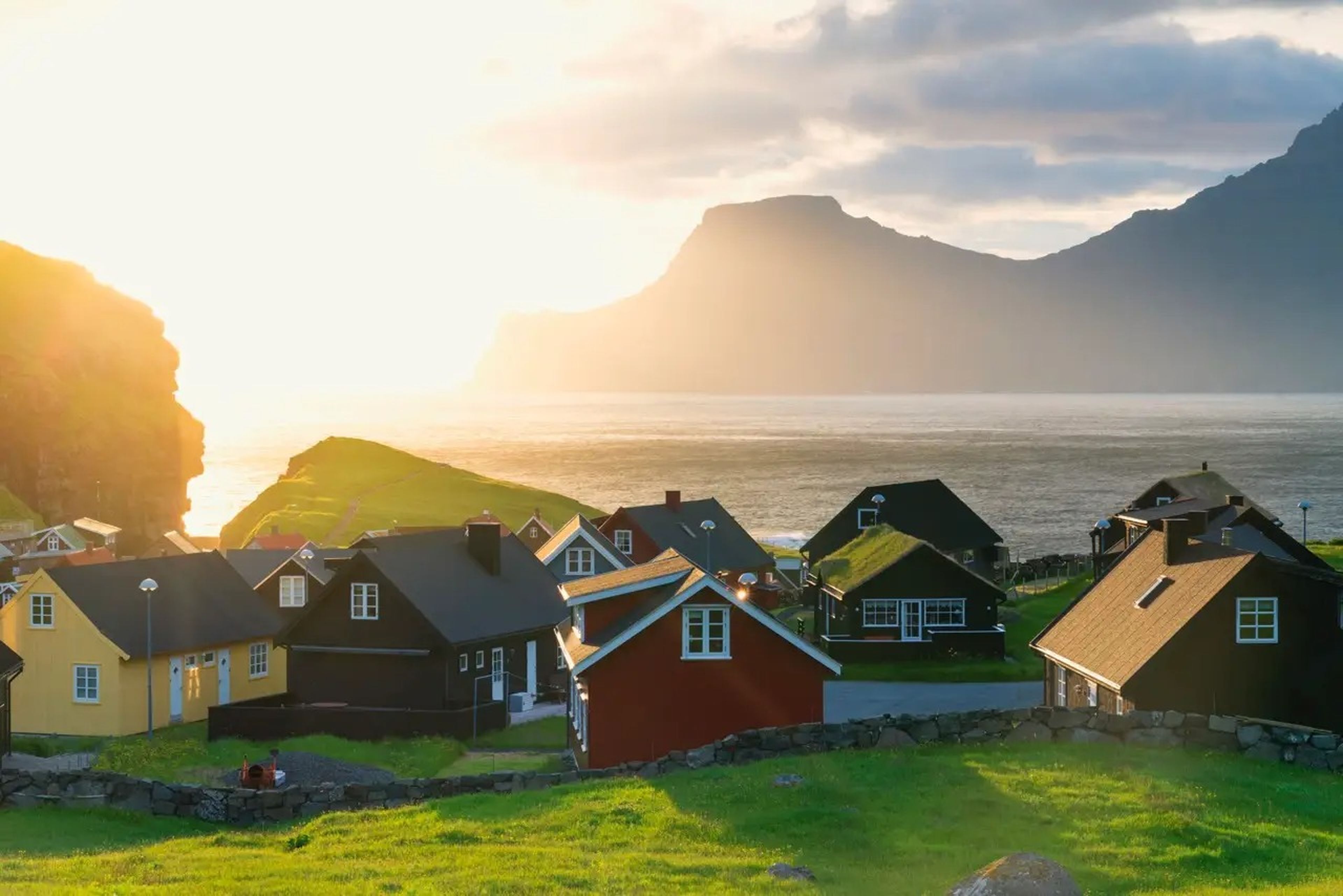 Sunrise over red and yellow seaside cottages on the Faroe Islands
