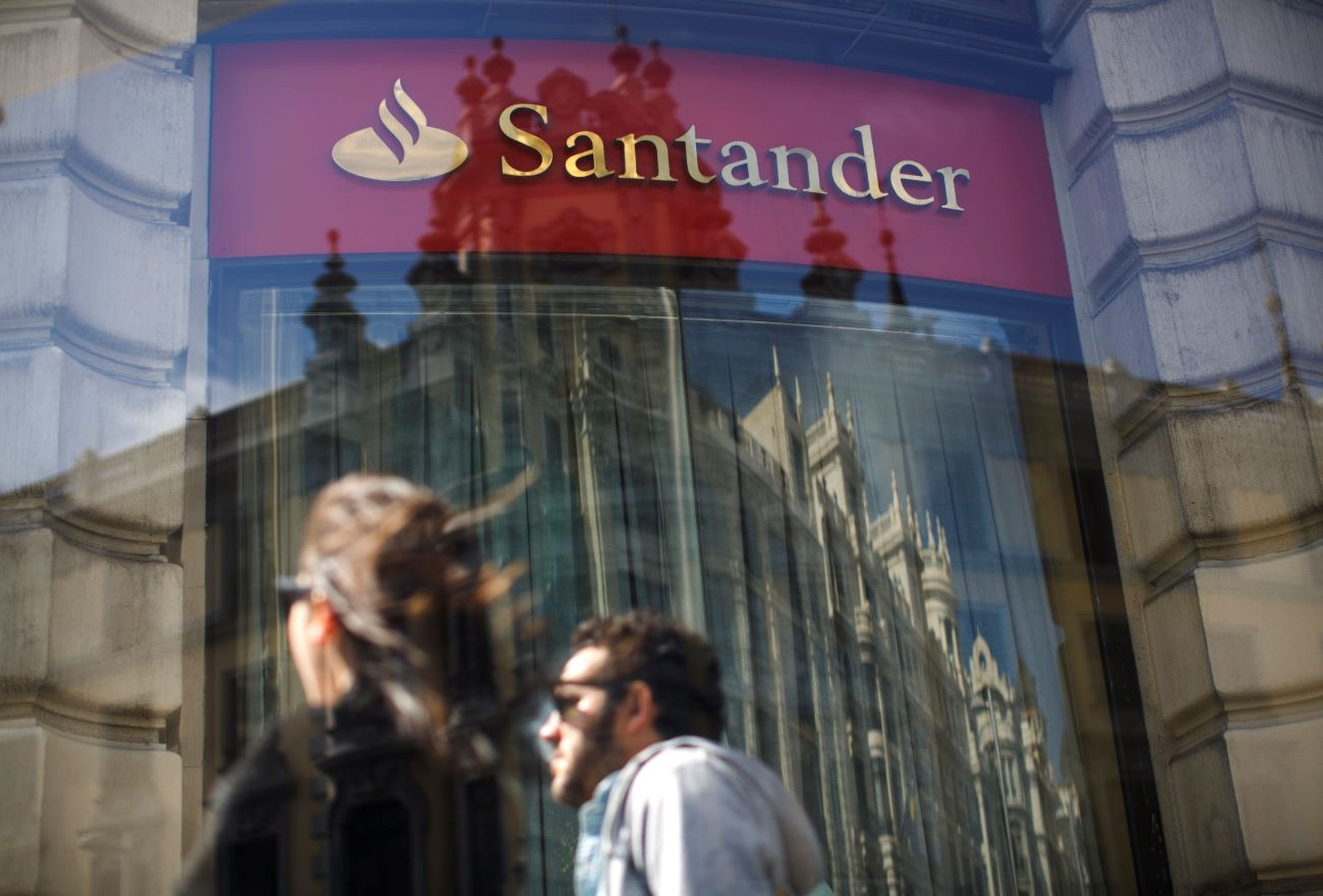 Banco Santander, personas caminan, reflejo