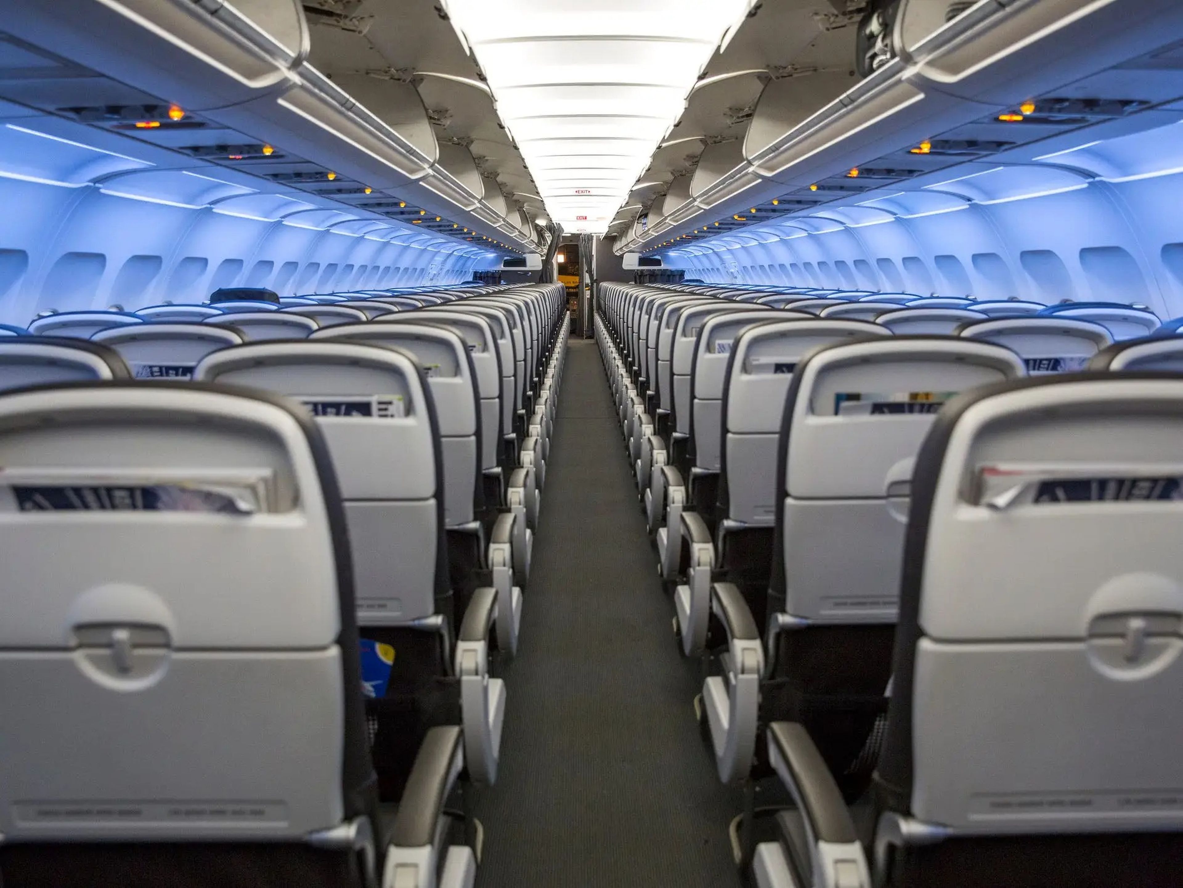 The interior of a plane, with empty seats.