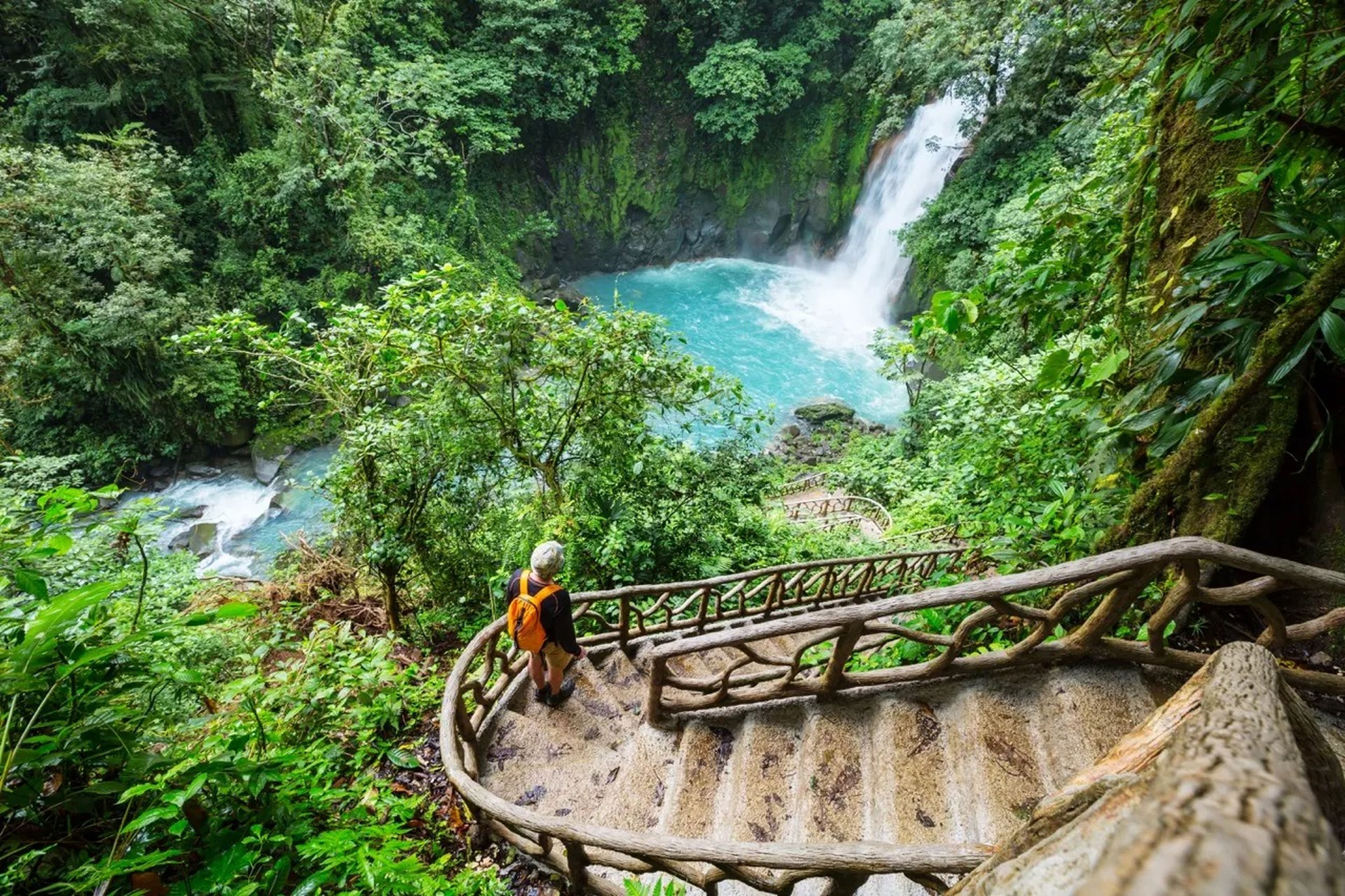 Man walking near waterfall in the rainforest jungle of Costa Rica