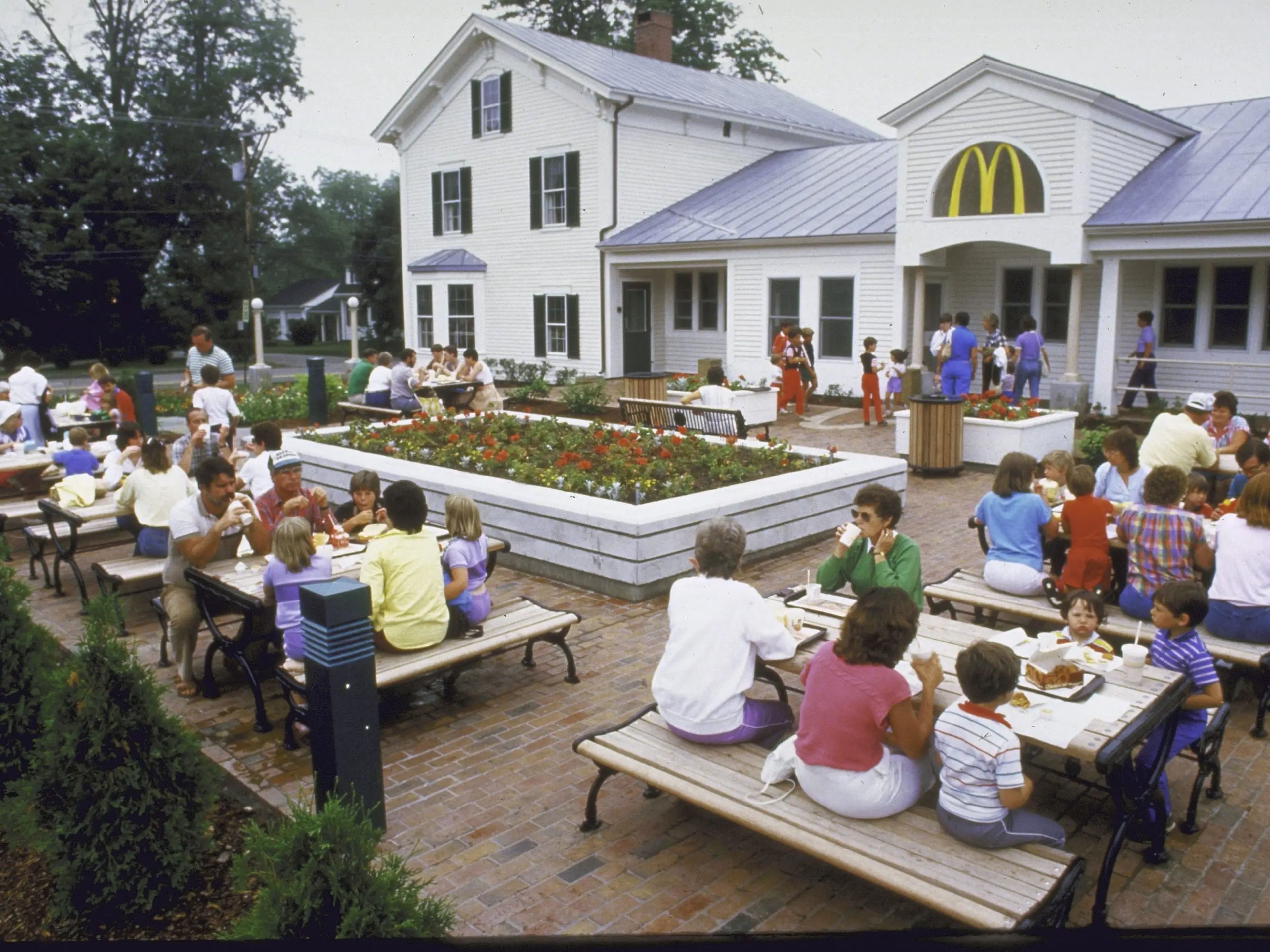 Exterior de un McDonald's mientras la gente come en mesas de picnic en agosto de 1985.