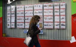 Una mujer pasea frente a anuncios de viviendas en alquiler