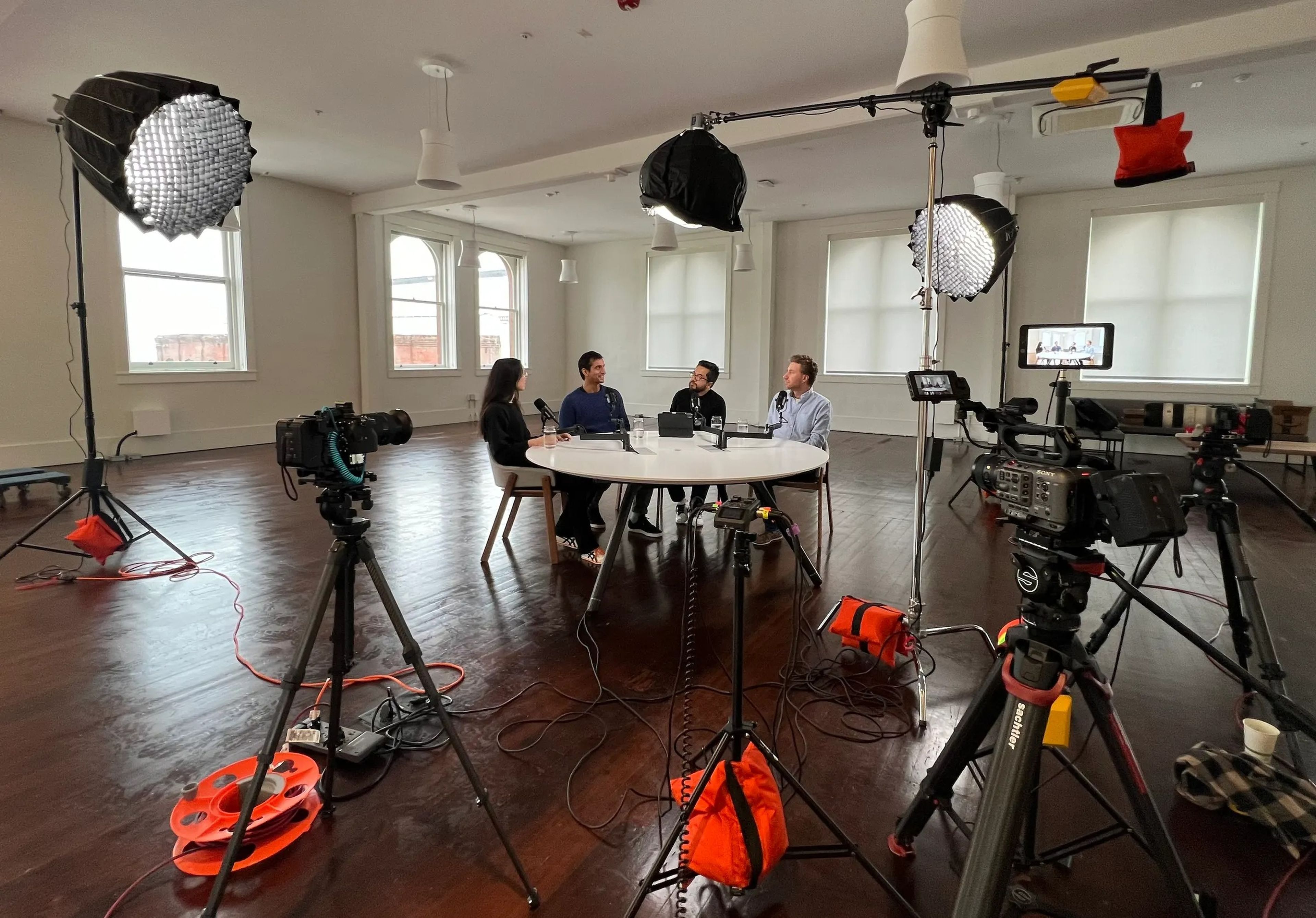 In a production studio complete with professional cameras and lighting fixtures, Y Combinator partners Diana Hu, Harj Taggar,  Garry Tan, and Jared Friedman record an episode of the Lightcone podcast.