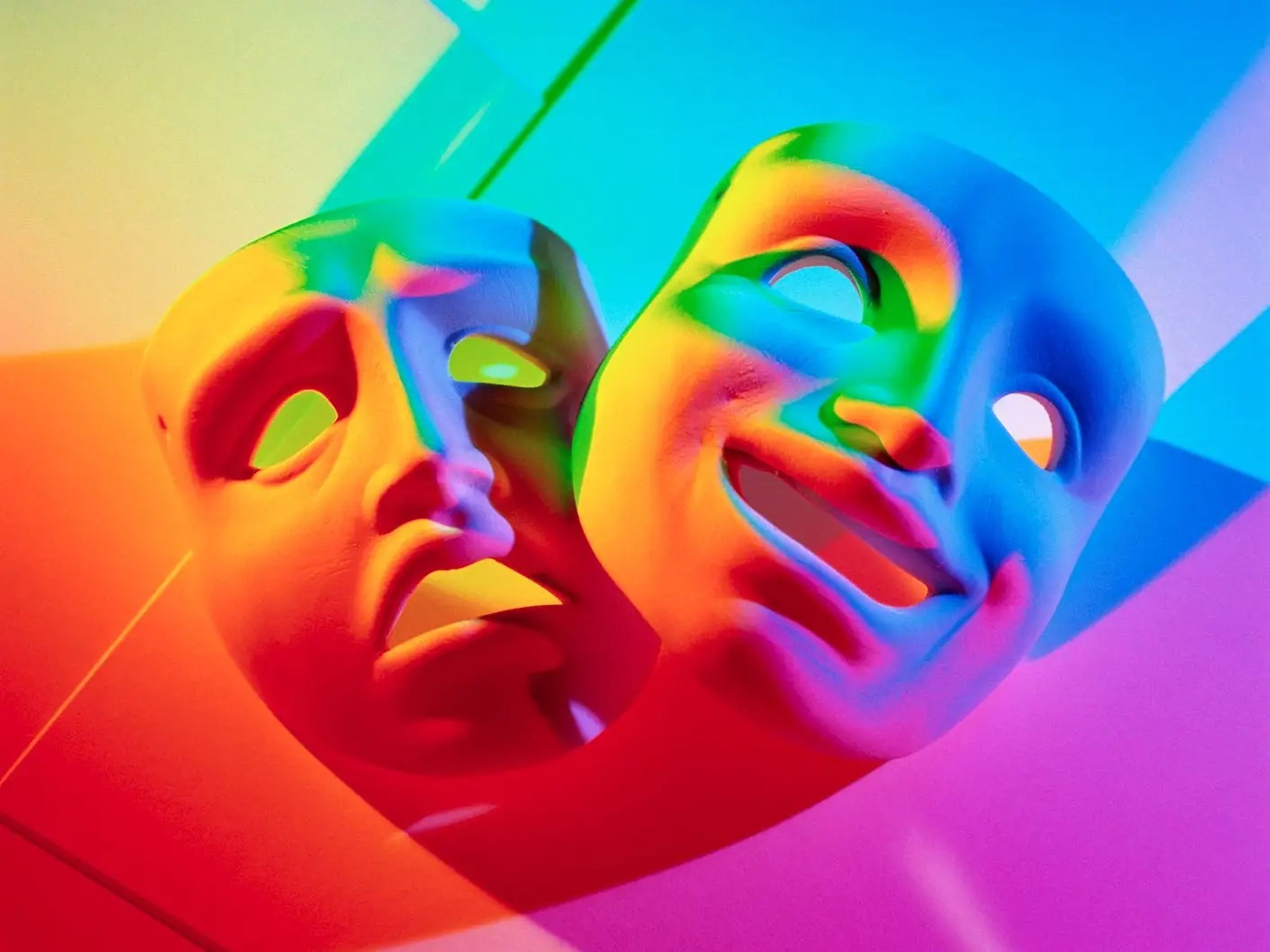 A rainbow image of happy and sad masks