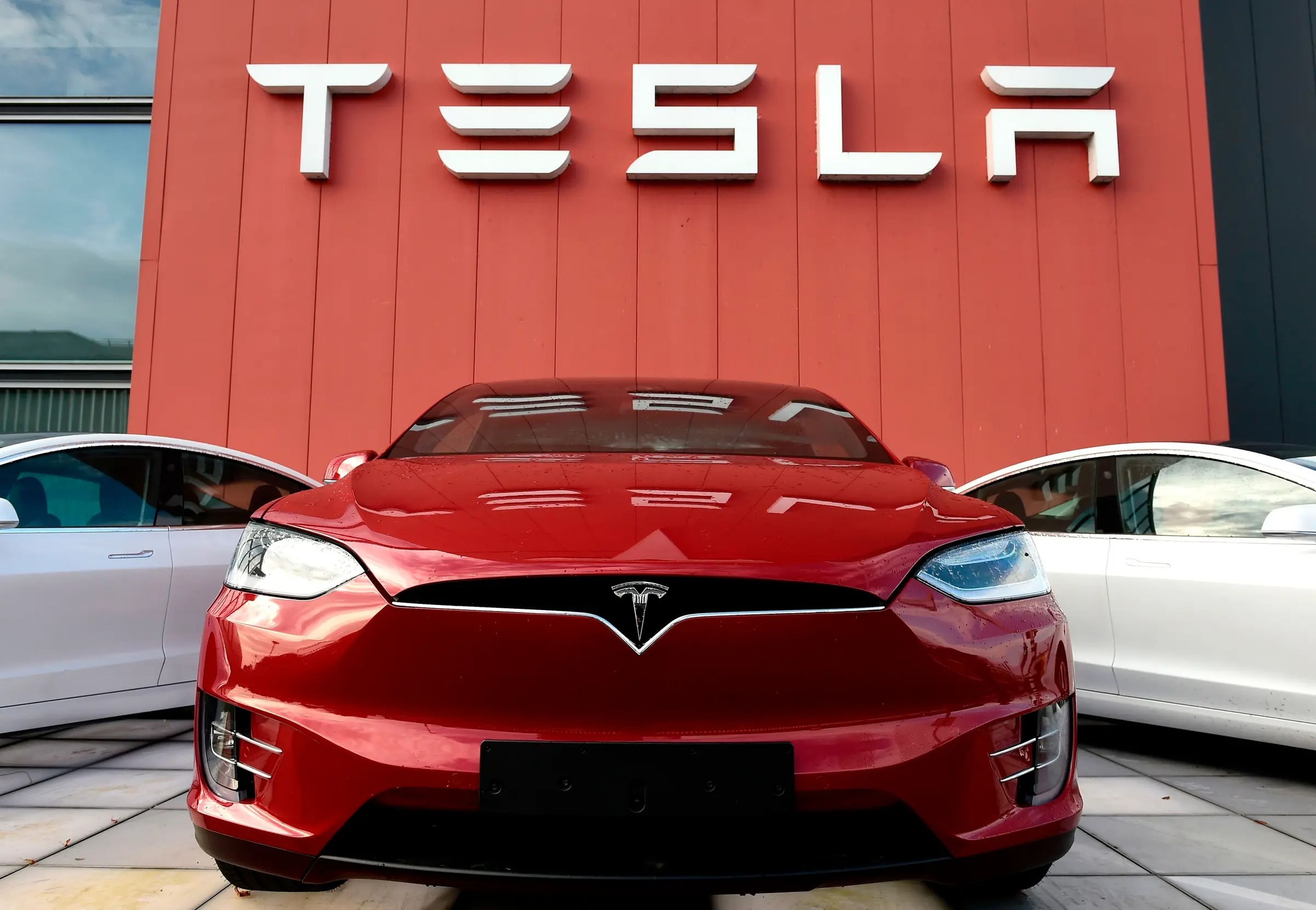 Un Tesla rojo fuera de una sala de exposición de Tesla.