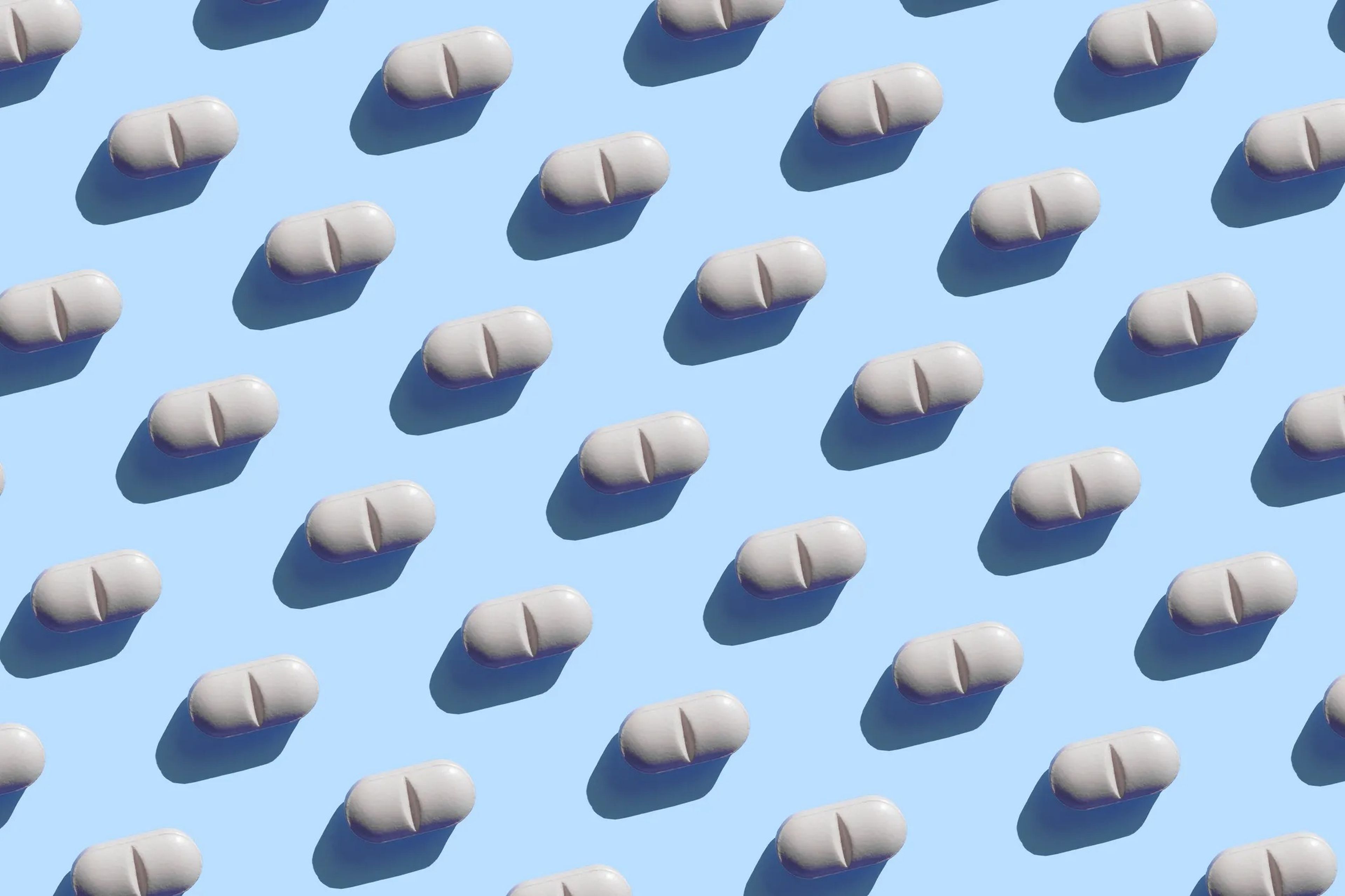 White pills in lines on a blue background.