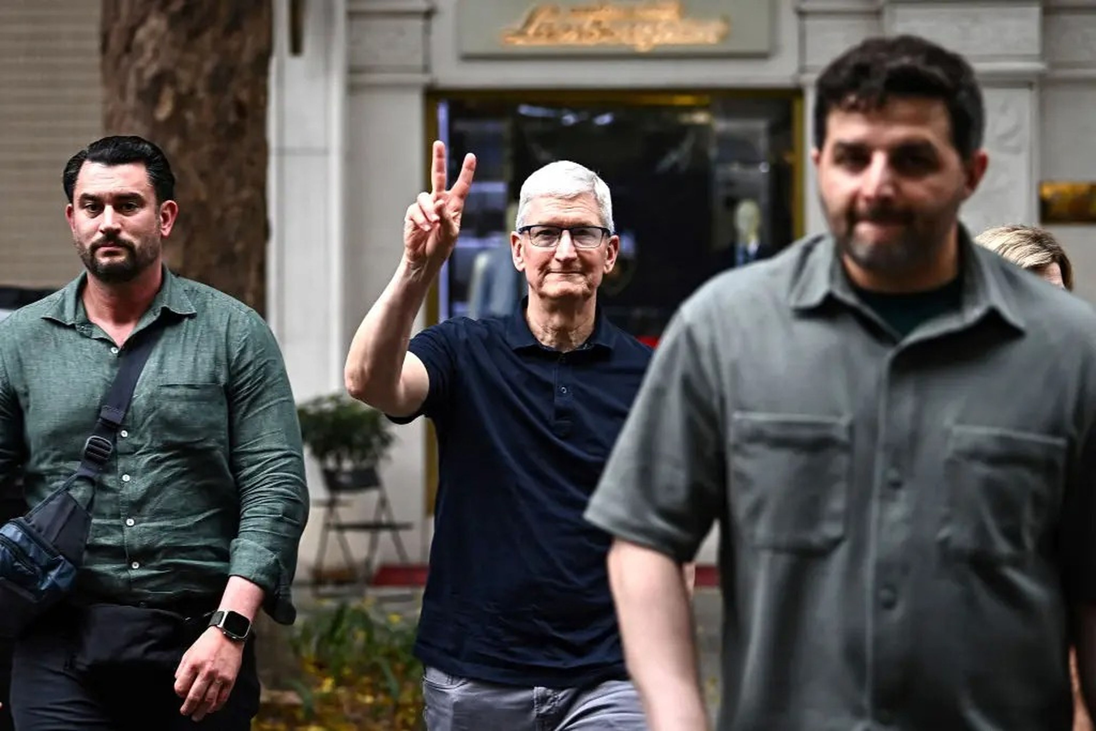 Apple CEO Tim Cook (C) gestures while crossing a street in downtown Hanoi during his visit to Vietnam on April 15, 2024.