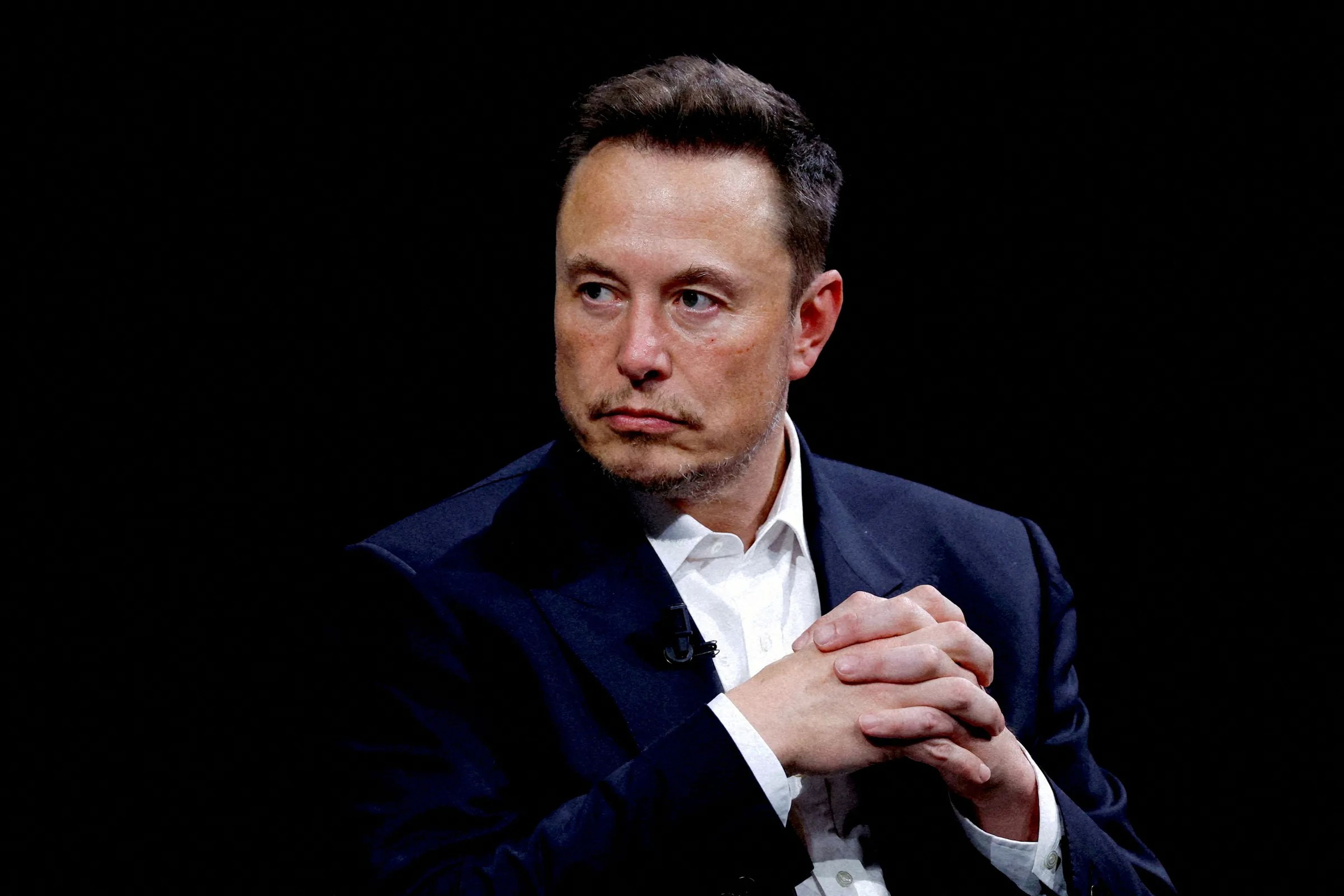 Elon Musk juntando las manos.