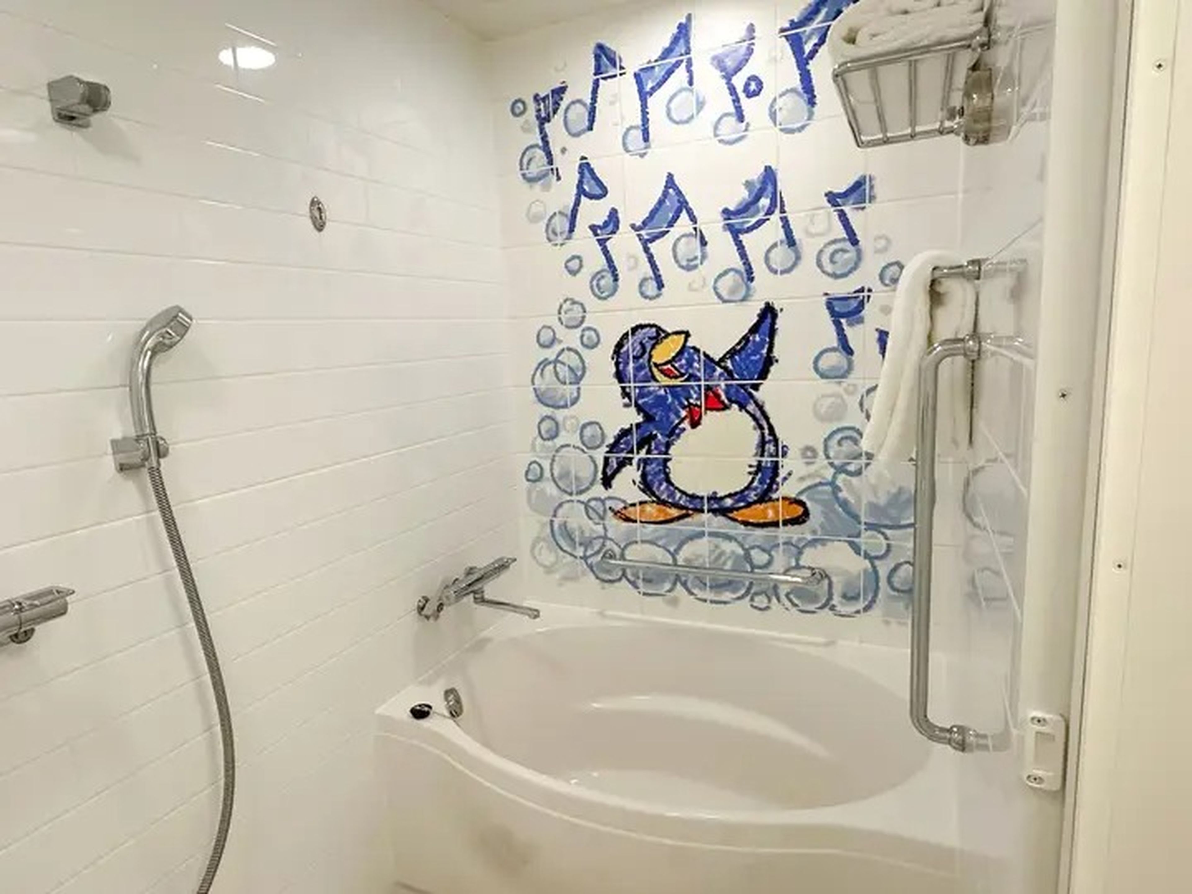 A guest bathroom at Tokyo's Toy Story Hotel features file with a Wheezy character singing in the tub with blue bubbles and music notes surrounding him.