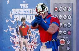 John Cena, a cast member in "The Suicide Squad," poses in front of a poster.