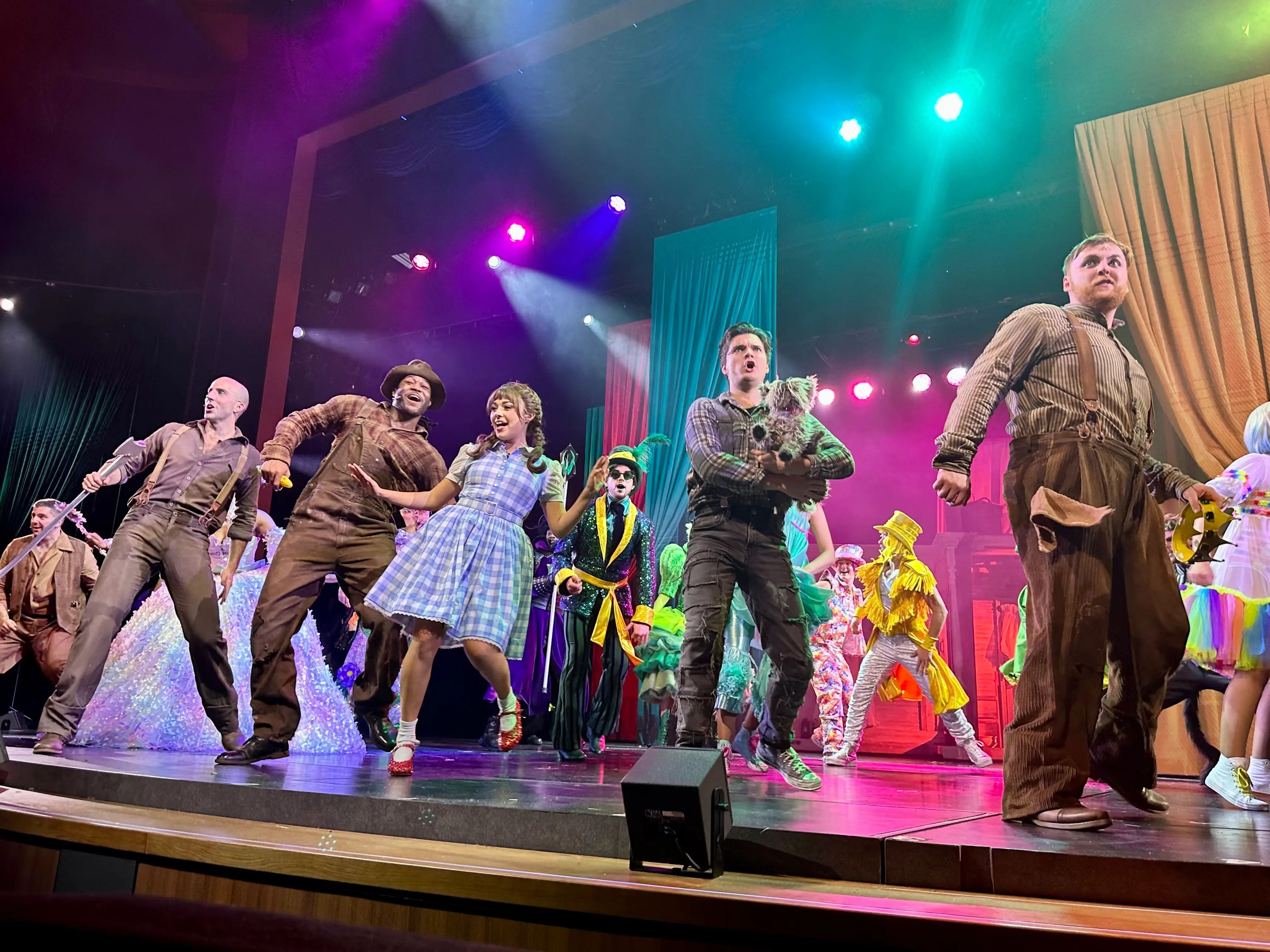 Performers in "Wizard of Oz" costumes performing on stage.