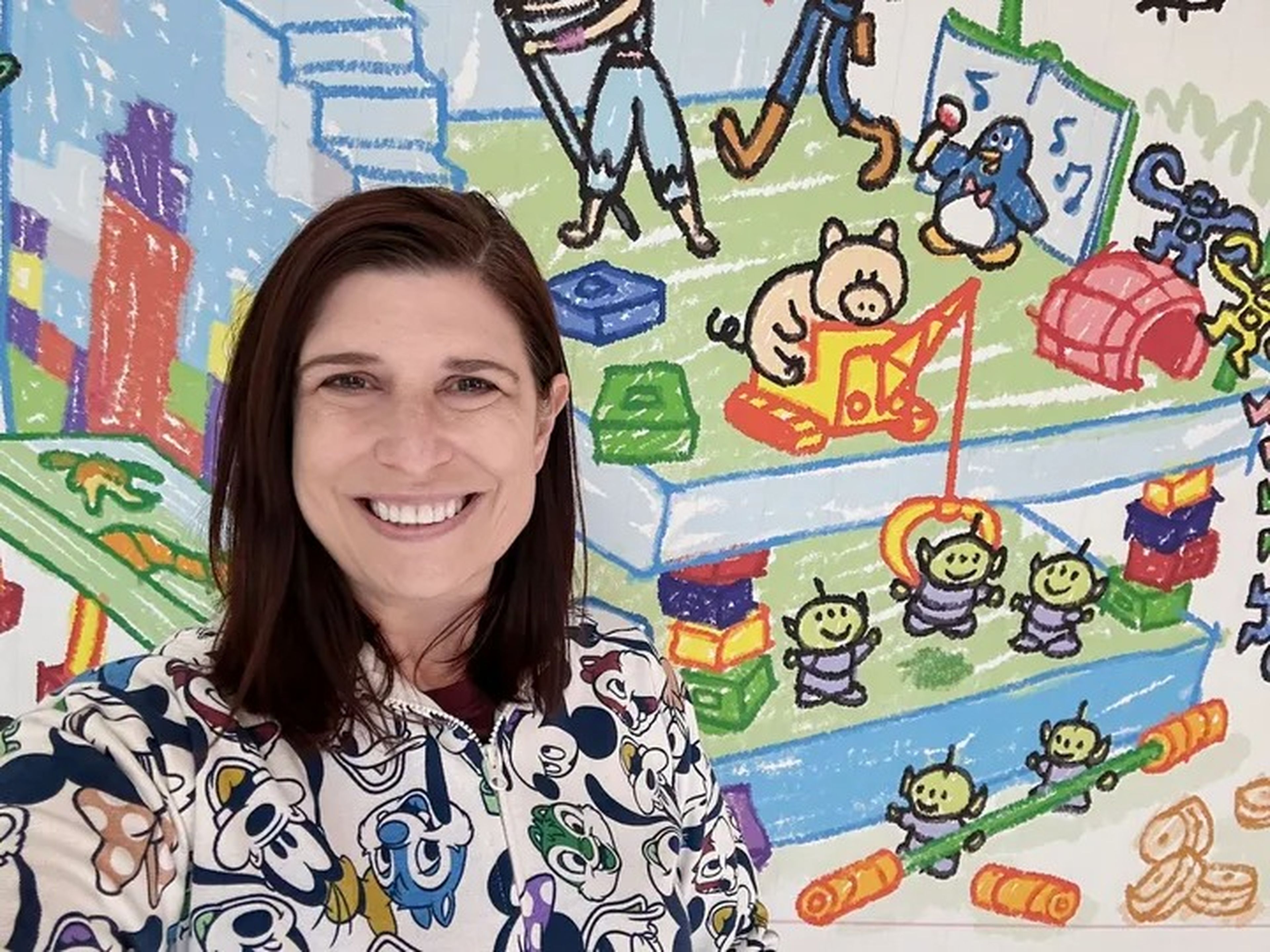 Writer Amanda Adler stands in front of a cartoon mural at the Toy Story Hotel, located near the theme parks at Tokyo Disney Resort.