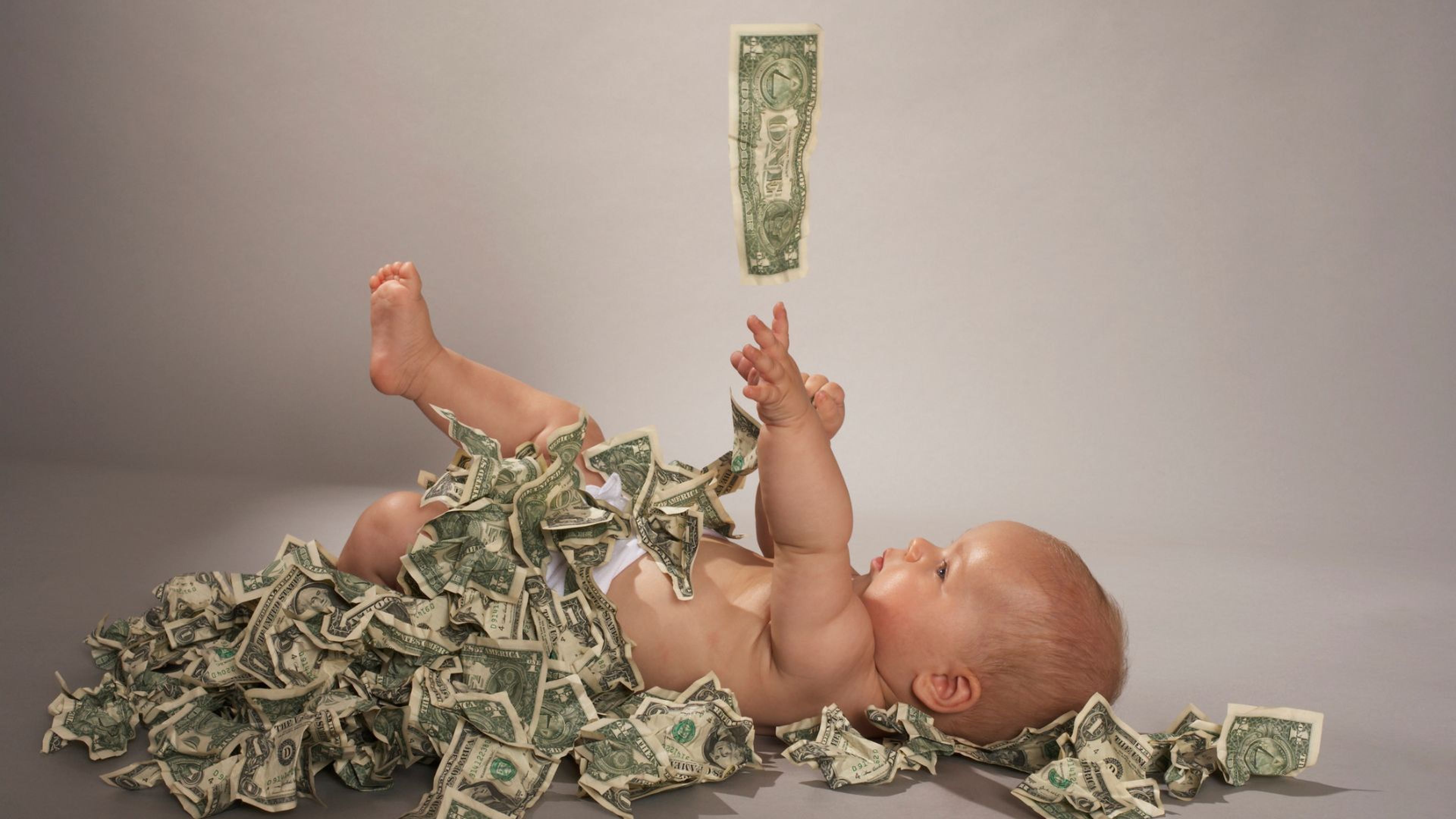 Un bebé con muchos billetes de dólar.