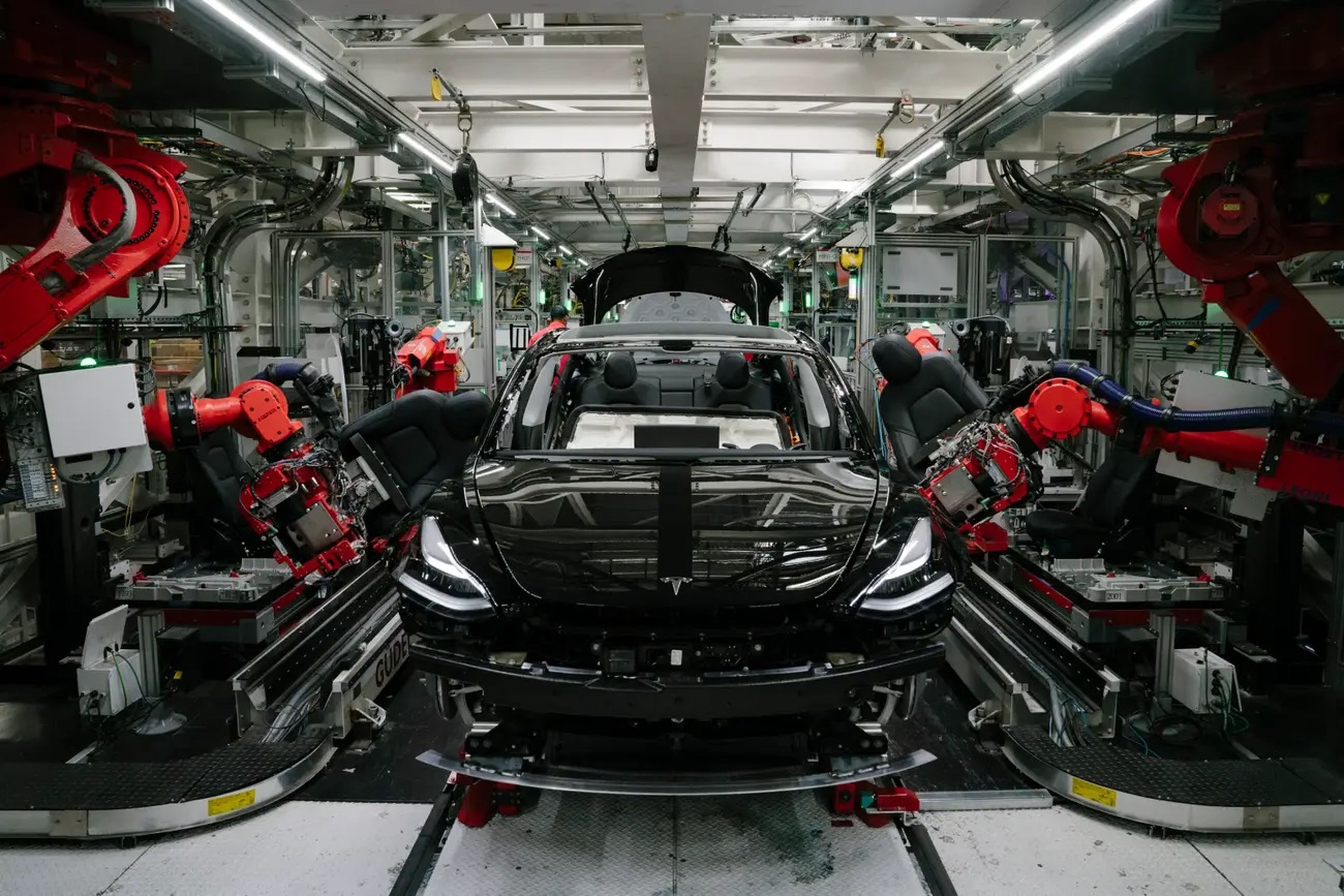Brazos robóticos instalando los asientos delanteros del Tesla Model 3 en la fábrica de la compañía en Fremont, California.