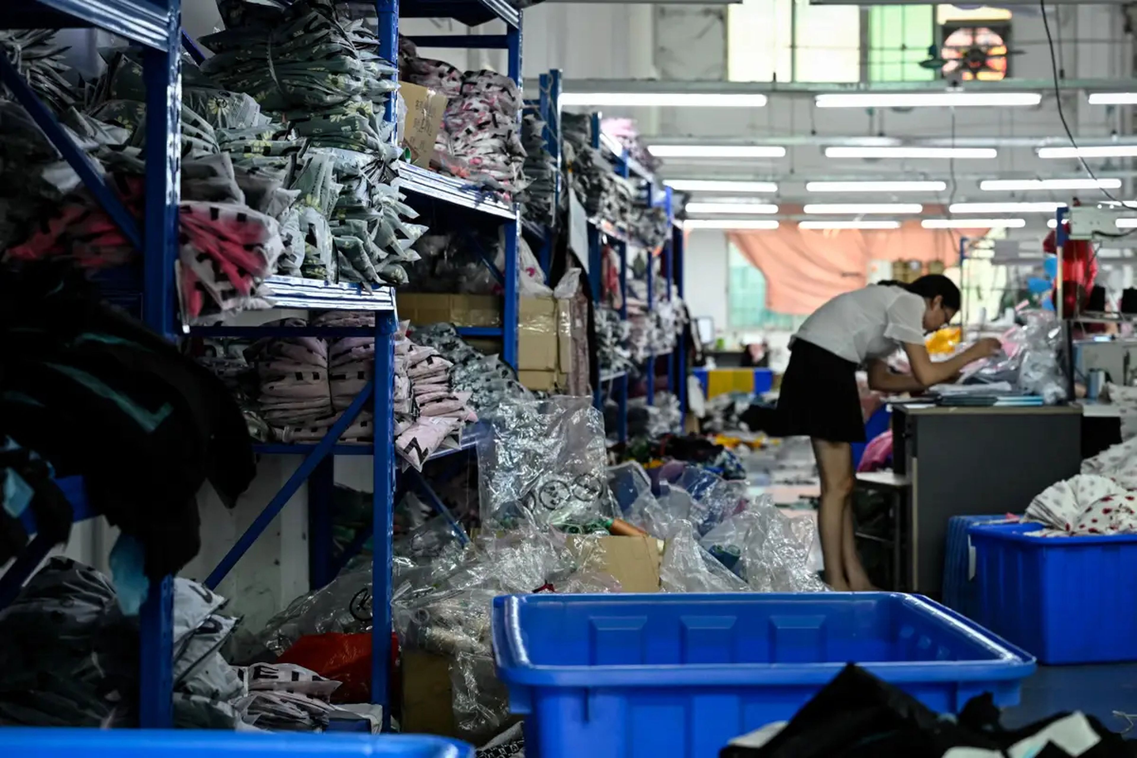 Un trabajador confecciona prendas en una fábrica de ropa que suministra a SHEIN.