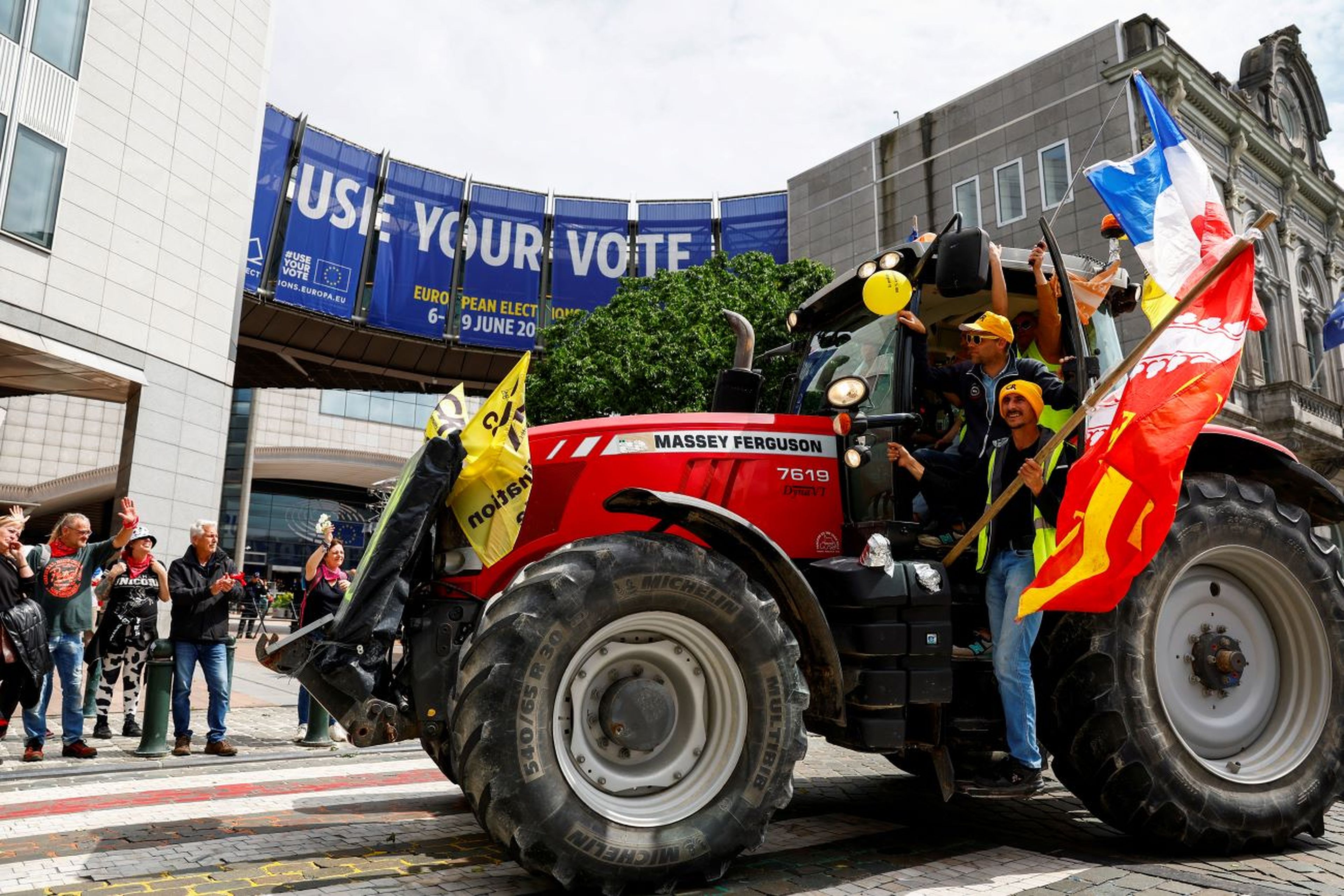 Trabajadores agrícolas en un tractor se manifiestan frente al Parlamento Europeo
