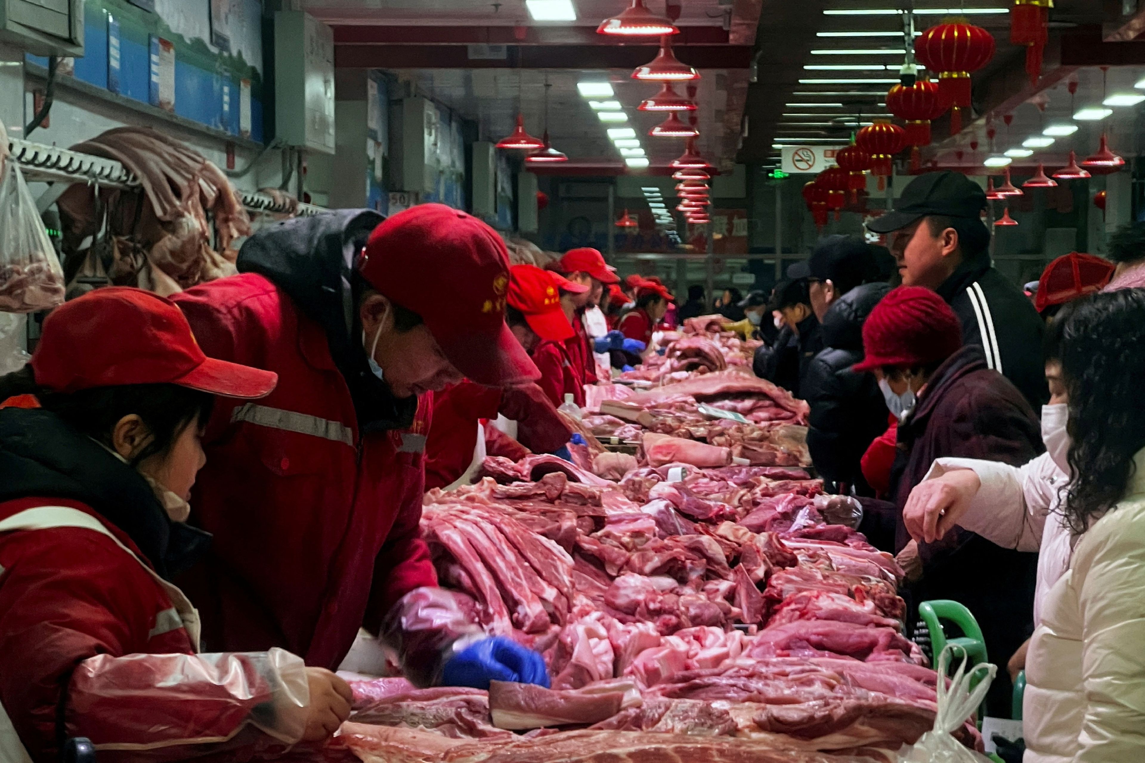 Vendedores de carne de cerdo atienden a los clientes en un mercado de Pekín. 