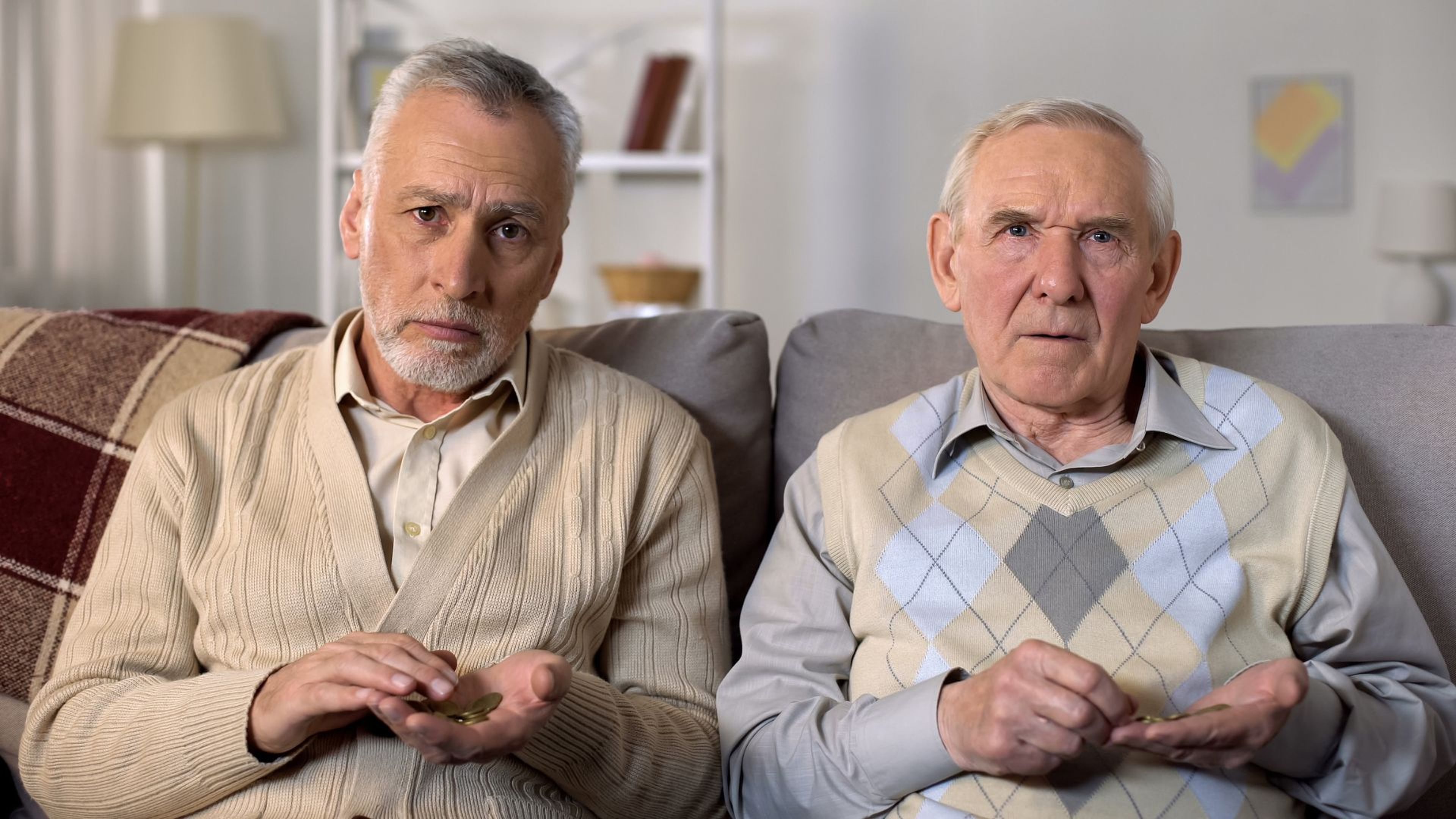 Dos hombres de avanzada edad con cara de pena.