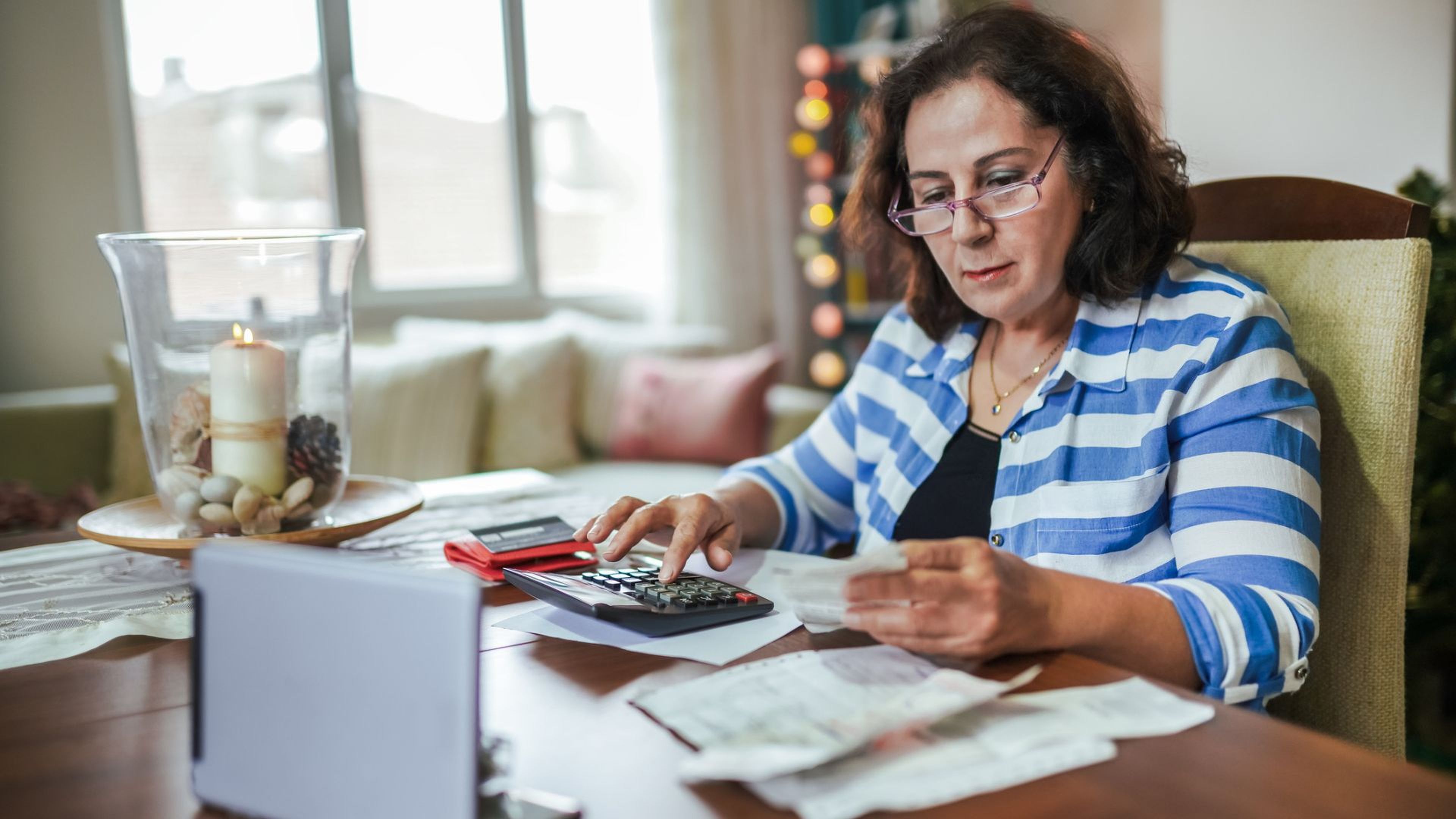 Una mujer hace cuentas con una calculadora.