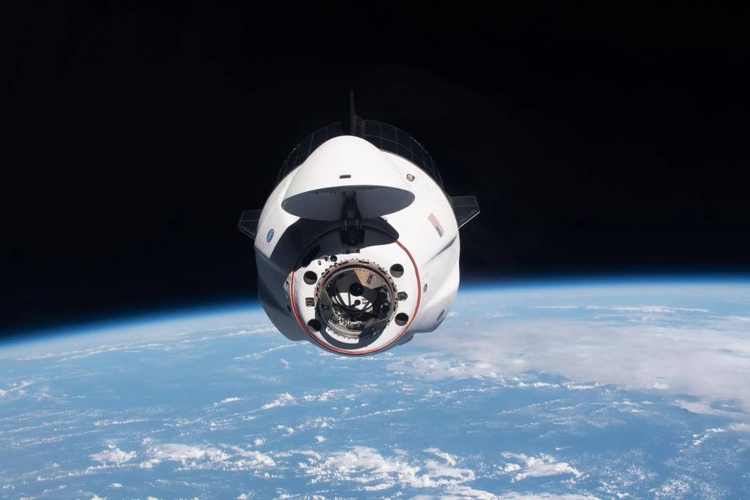 Una nave espacial Dragon se aproxima a la Estación Espacial Internacional con astronautas a bordo.