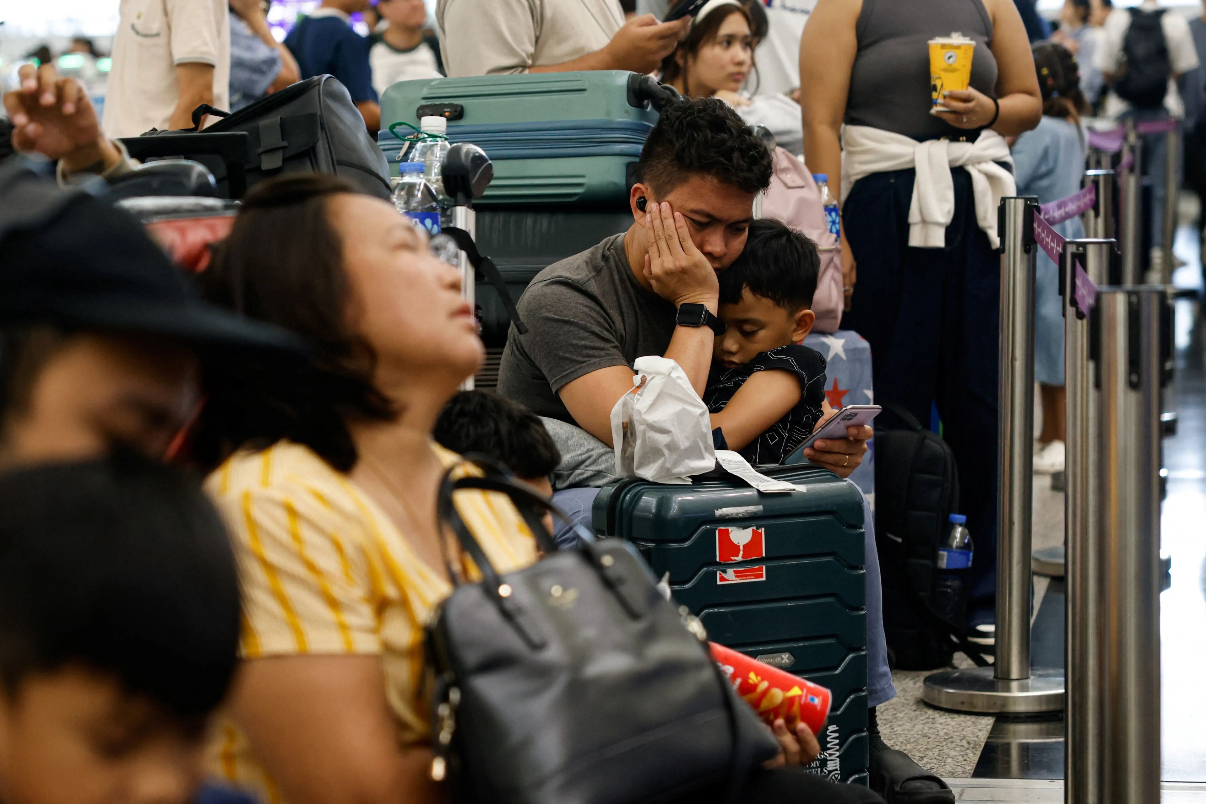 Pasajeros haciendo cola en los mostradores del aeropuerto internacional de Hong Kong, en el que la caída del sistema informático interrumpió las operaciones de las aerolíneas.