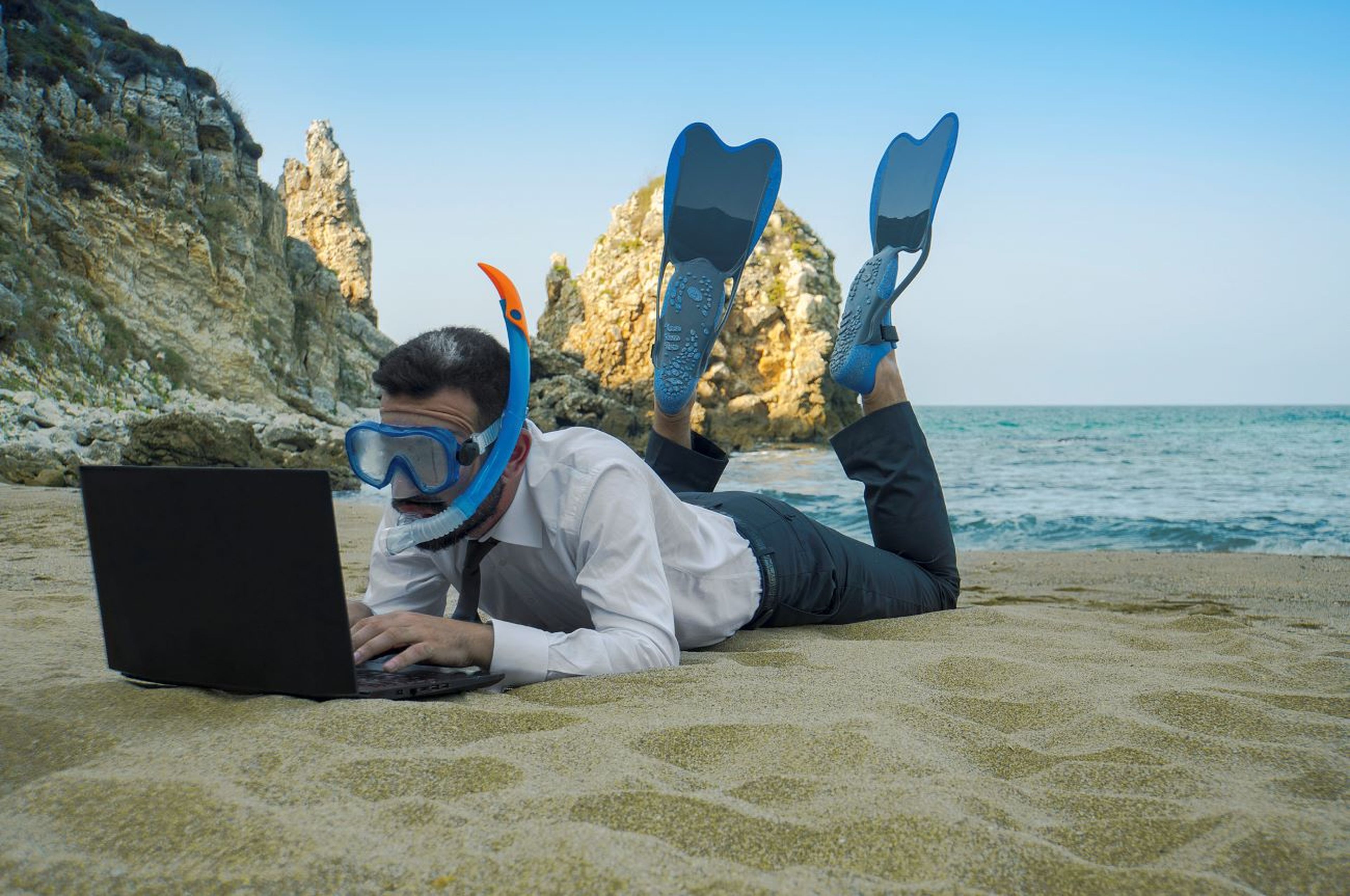 Trabajador en la playa, snorkel, ordenador