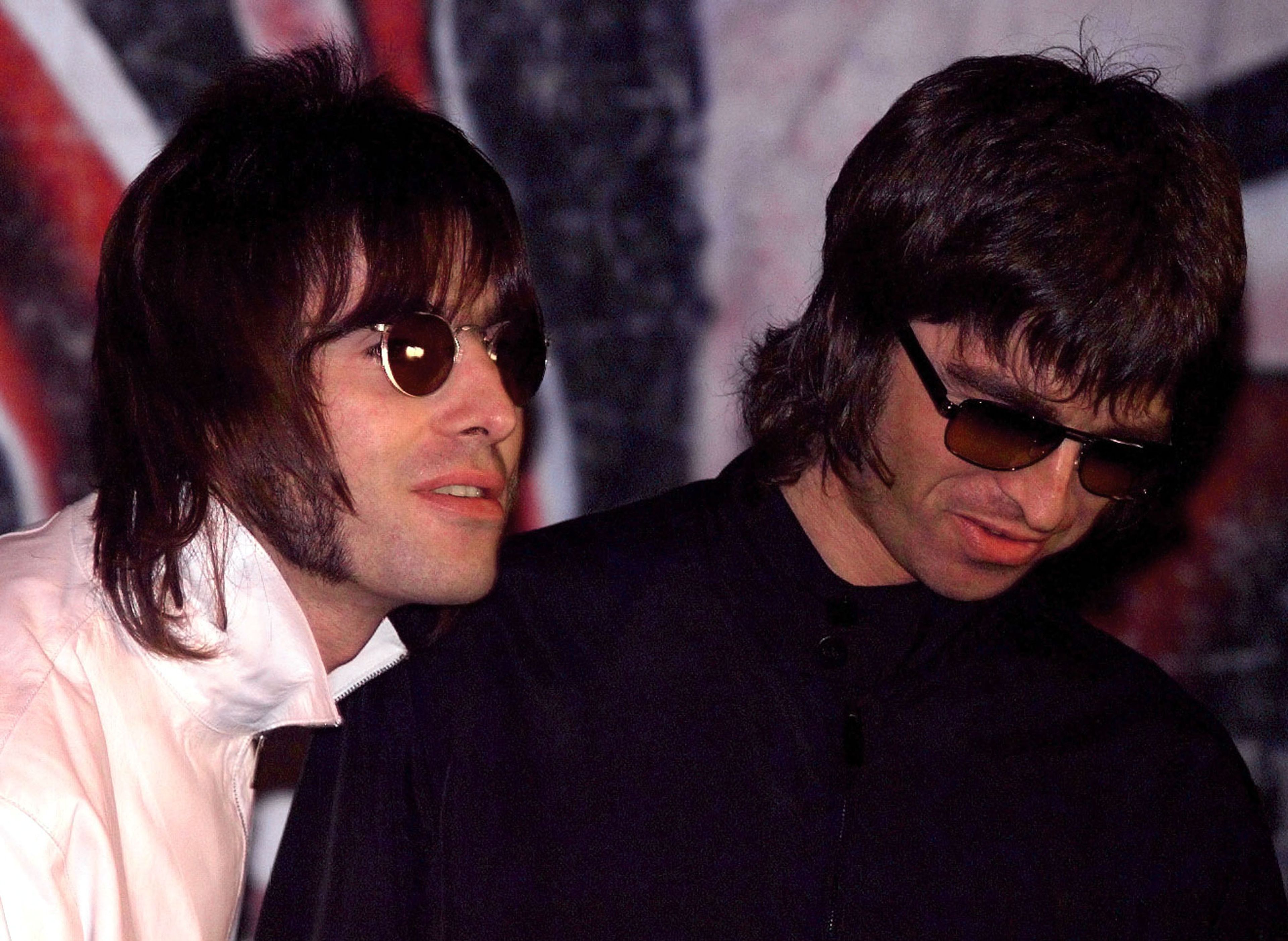 Liam (izda) y Noel (dcha) Gallagher, de la banda británica Oasis, en una rueda de prensa en 1999 en la que anunciaban su continuidad pese a la reciente salida de otros integrantes del grupo.