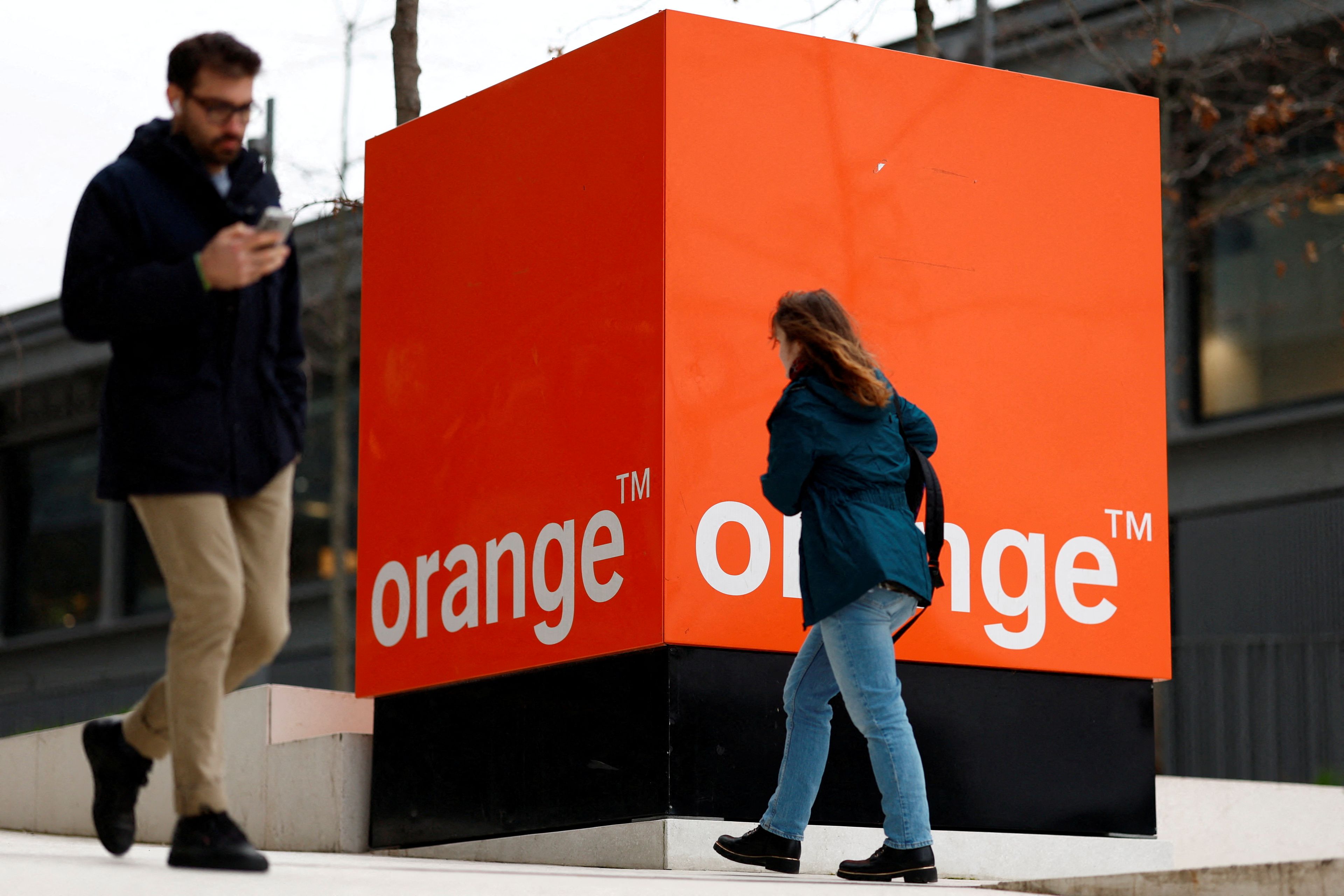 Dos personas pasean delante de la sede de Orange, en Francia.