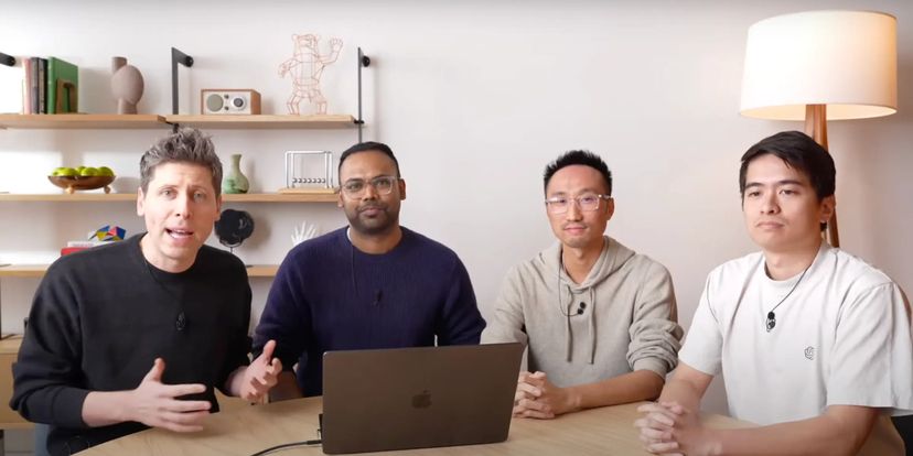 OpenAI CEO Sam Altman sitting with Yash Kumar, Casey Chu, and Reiichiro Nakano around a computer.
