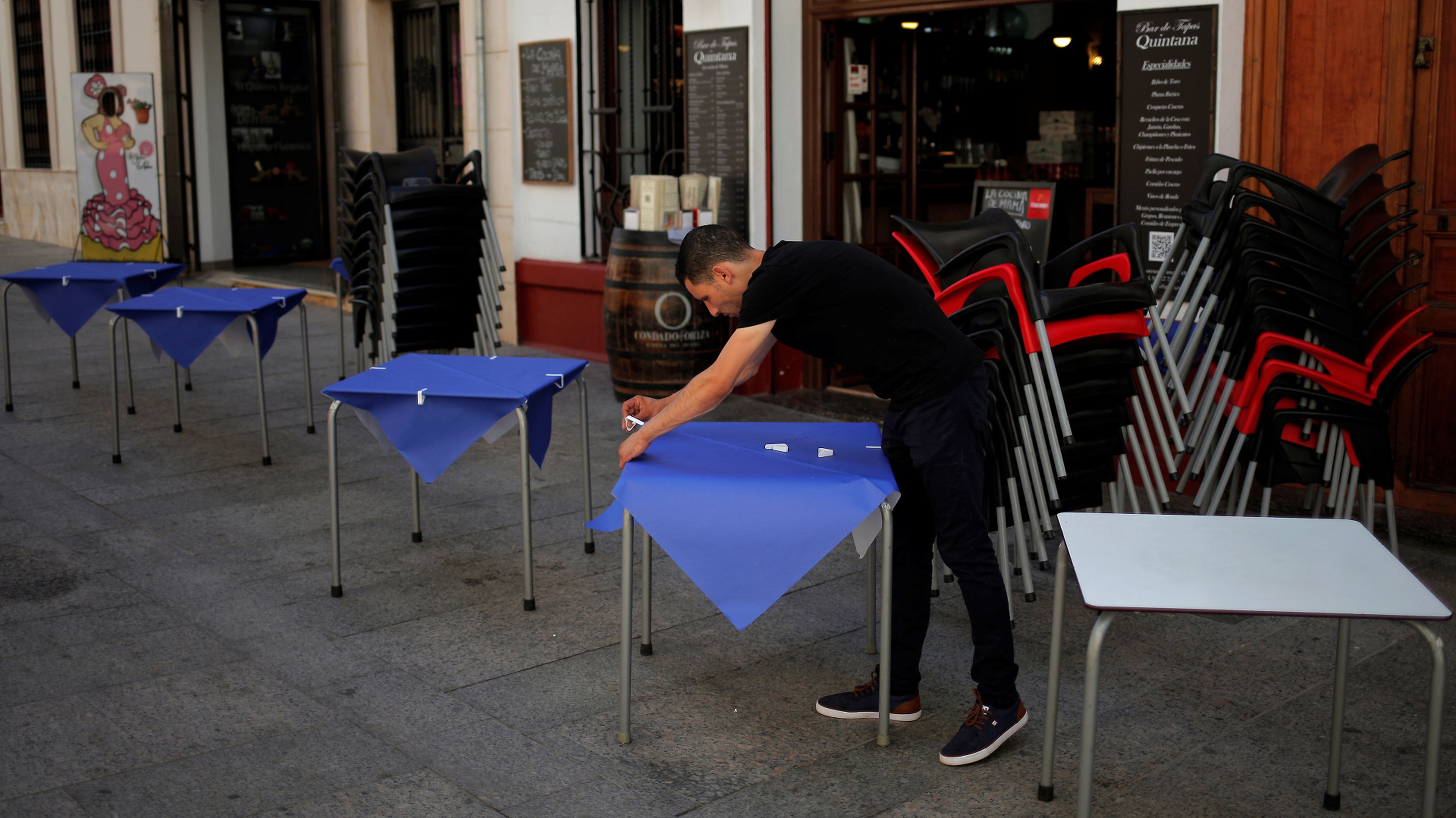 Un camarero prepara las mesas de una terraza en un restaurante de Ronda (Málaga)