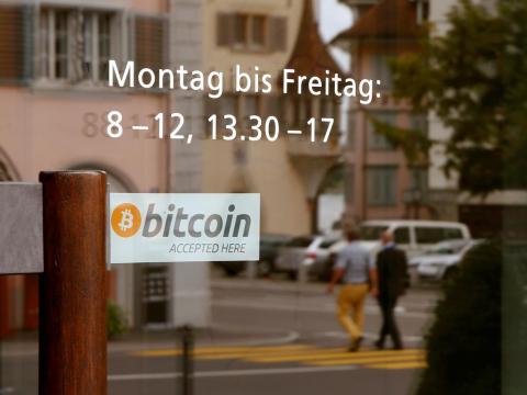 A sticker reading "Bitcoin accepted here" is placed at the entrance of the Stadthaus town hall in Zug.