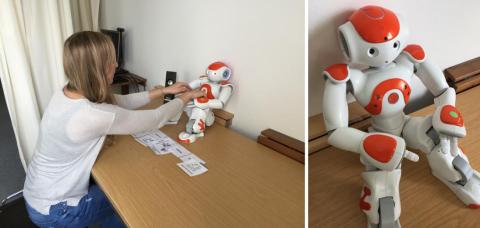 A participant in the experiment reaches forward to turn off the robot.