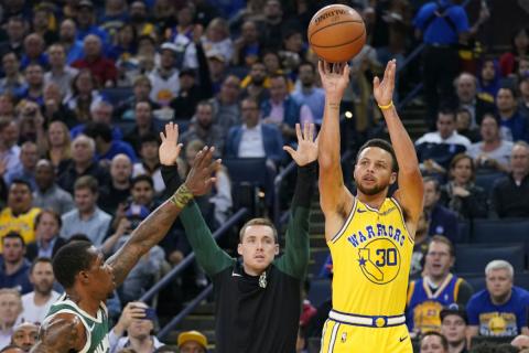 Stephen Curry lanza a canasta con los Warriors.