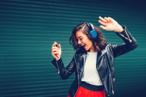 Chica escuchando musica con sus auriculares y el movil