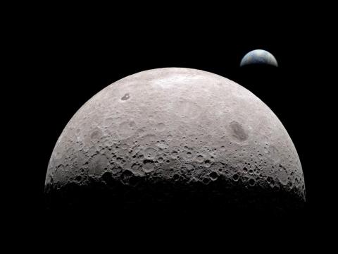 A simulated view of the moon from its far side with Earth in the background.