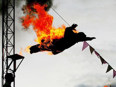 An acrobat sets himself on fire before diving into a swimming pool as part of a show. An acrobat sets himself on fire before diving into a swimming pool as part of a show.