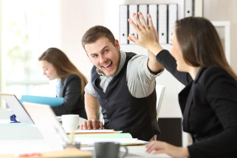 Dos empleados chocan la mano en el trabajo Dos empleados chocan la mano en el trabajo