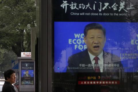 A man walks by electronic display panels advertising a video footage of Chinese President Xi Jinping speaking at the World Economy Forum on a street in Beijing, Monday, June 25, 2018. A man walks by electronic display panels advertising a video footage of Chinese President Xi Jinping speaking at the World Economy Forum on a street in Beijing, Monday, June 25, 2018.