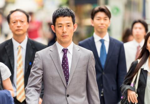Un grupo de trabajadores japoneses camina por la calle Un grupo de japoneses de camino a su trabajo