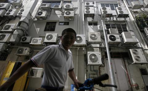 Hombre frente a un edificio repleto de aire acondicionado en Singapore. Hombre frente a un edificio repleto de aire acondicionado en Singapore.