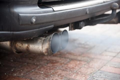 El humo del motor sale por el tubo de escape de un coche El humo del motor sale por el tubo de escape de un coche