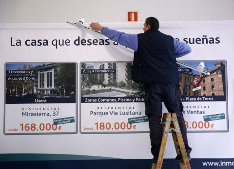 Un operario desmonta un cartel de viviendas en venta en Madrid Un operario desmonta un cartel de viviendas en venta en Madrid
