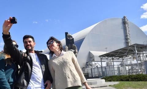 Tourists take a photo in front of the contained reactor site. Tourists take a photo in front of the contained reactor site.