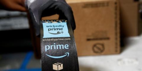 Un operario con un paquete de Amazon Un operario con un paquete de Amazon
