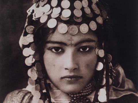 1900s: An Ouled Nail woman in Algeria displays her dowry of gold coins.